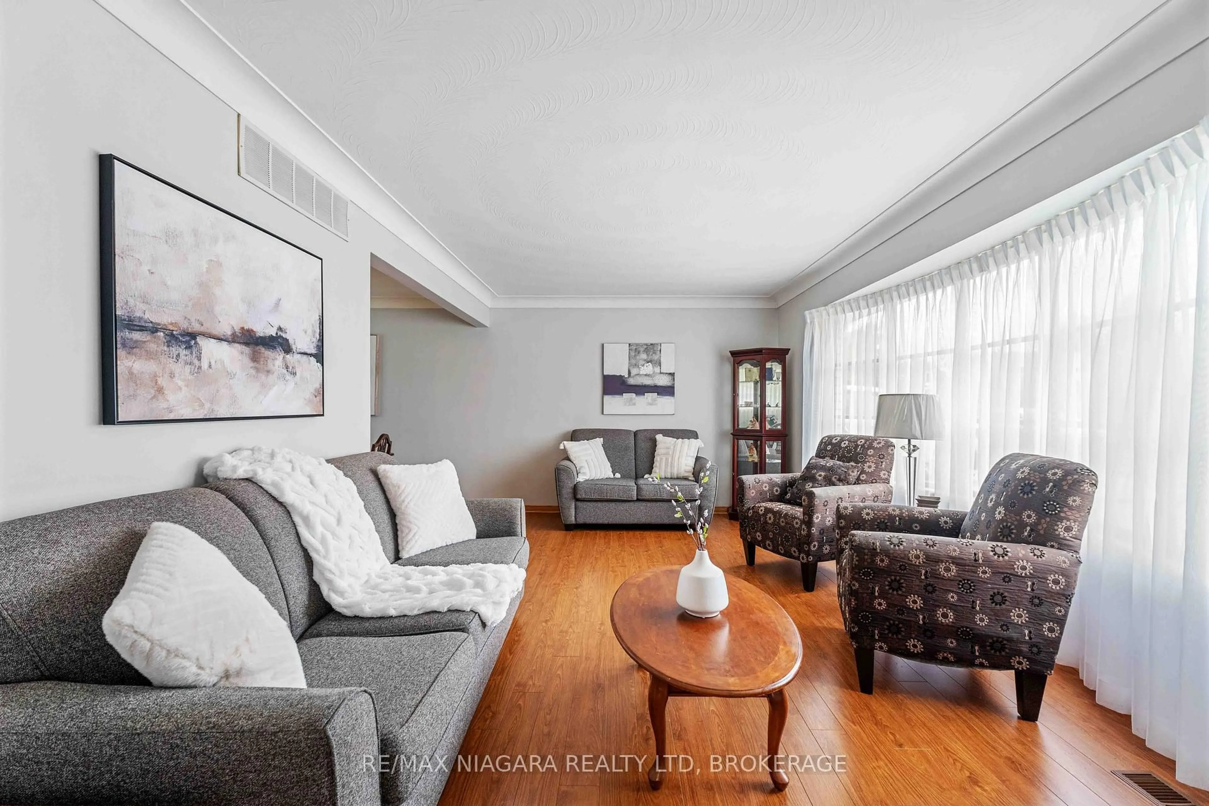 Living room with furniture, wood/laminate floor for 5840 Keith St, Niagara Falls Ontario L2J 1J9