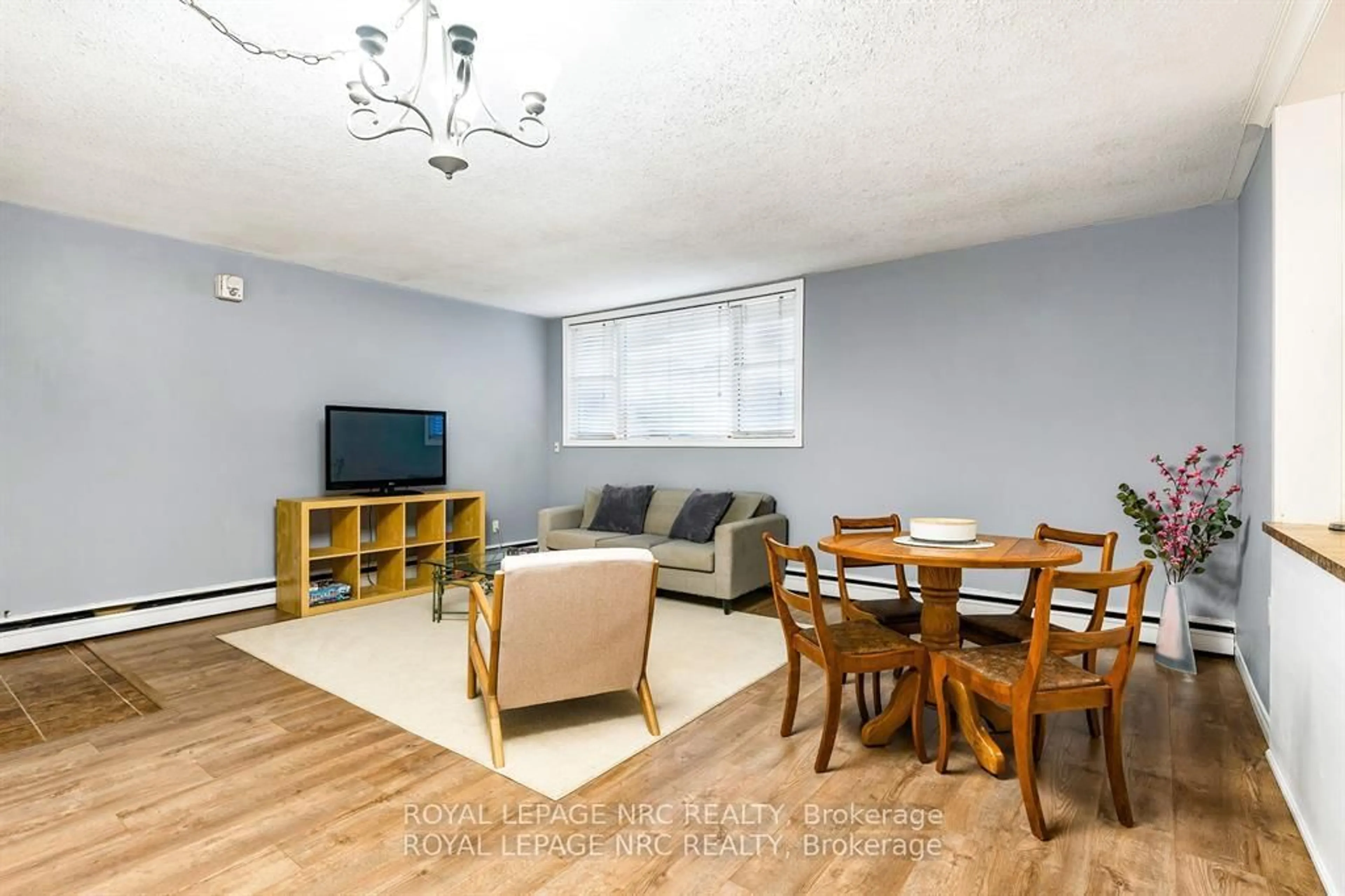 Living room with furniture, wood/laminate floor for 454 CARLTON St #7, St. Catharines Ontario L2M 4X1