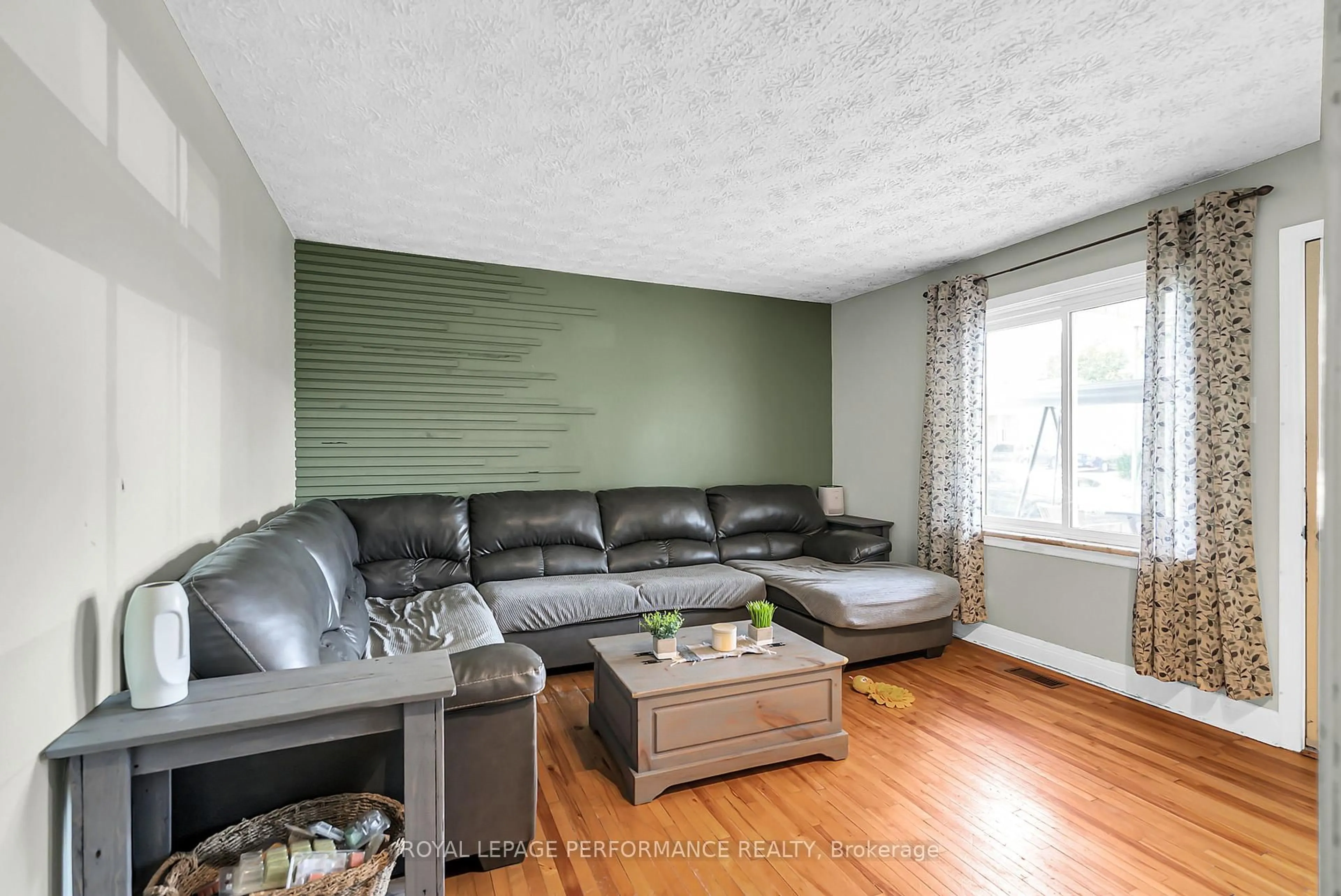 Living room with furniture, wood/laminate floor for 409 Belmont St, Cornwall Ontario K6H 4Z8