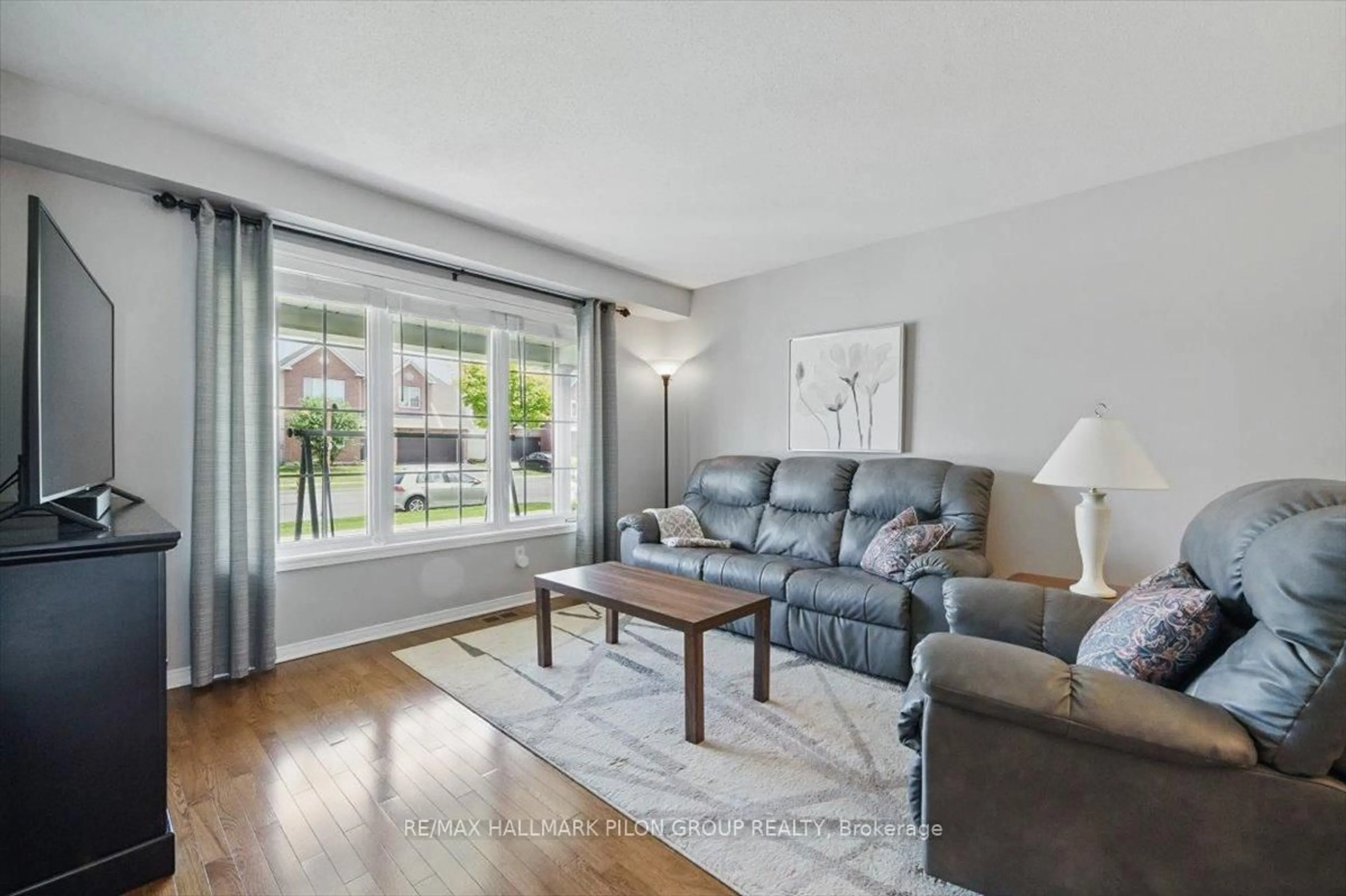 Living room with furniture, wood/laminate floor for 2112 Esprit Dr, Ottawa Ontario K4A 4G3