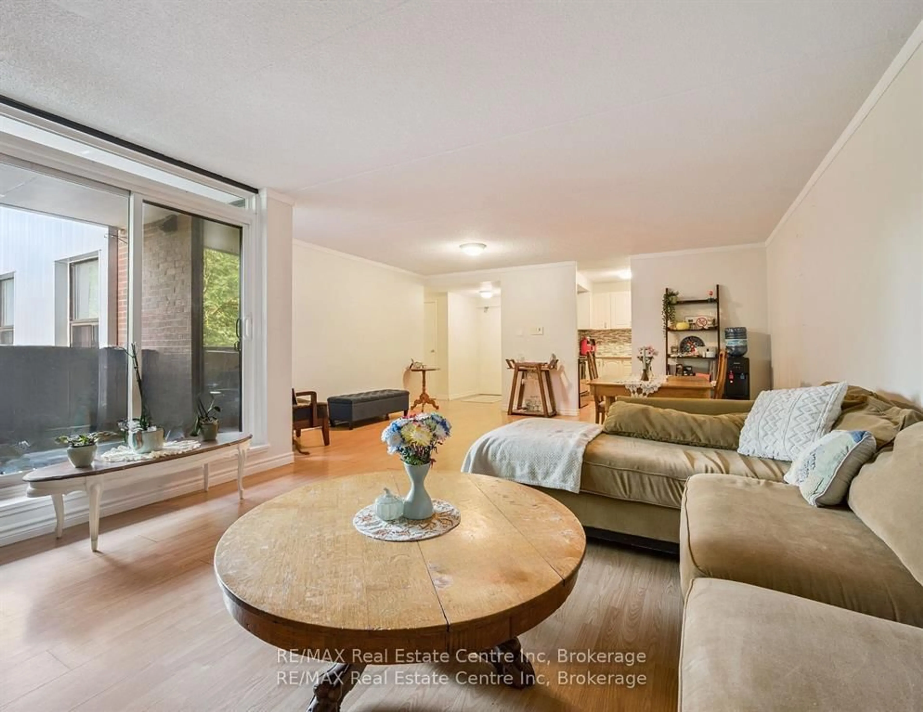 Living room with furniture, wood/laminate floor for 65 Silvercreek Pkwy #310, Guelph Ontario N1H 7R9