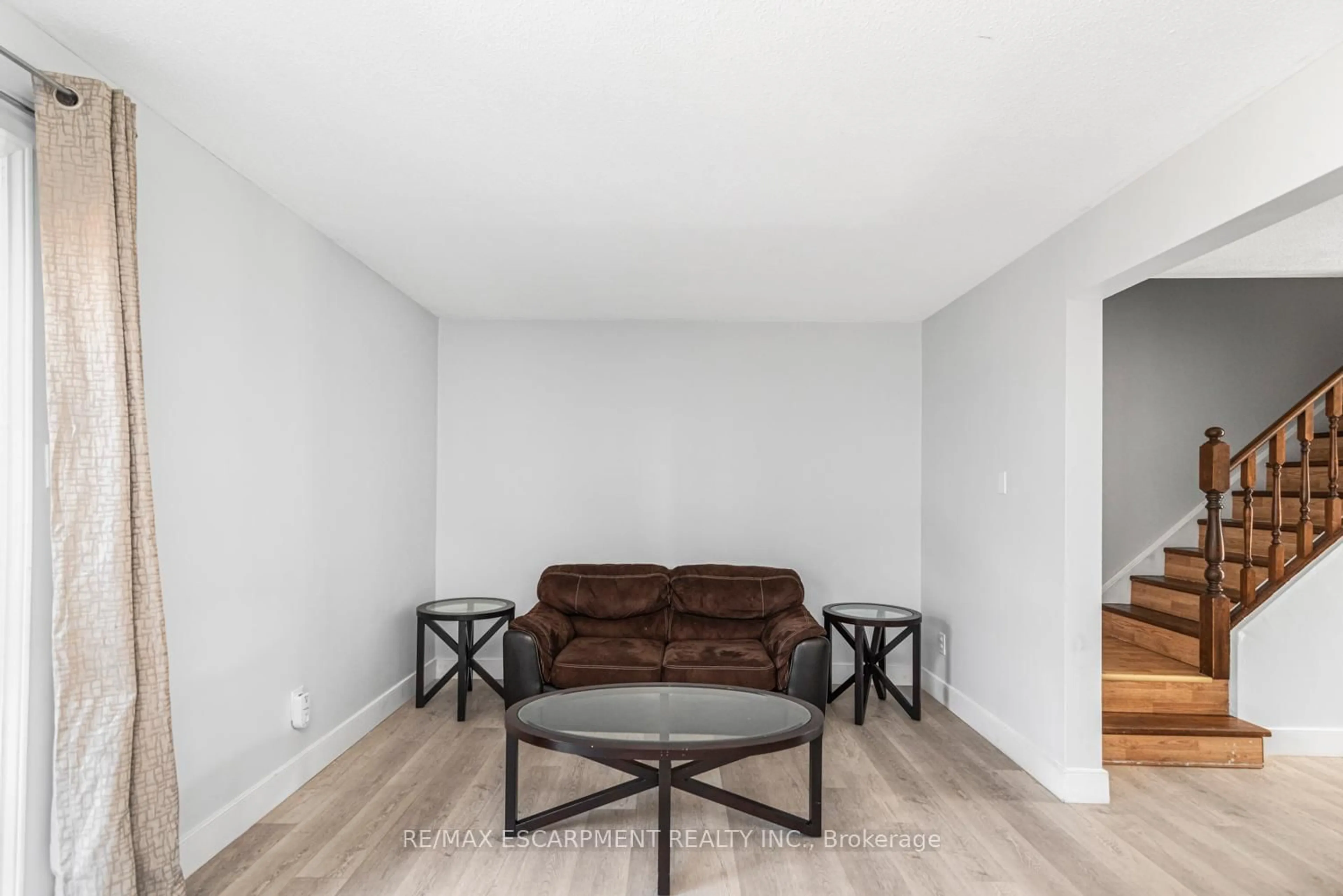 Living room with furniture, wood/laminate floor for 25 Bryna Ave #F, Hamilton Ontario L9A 4W9