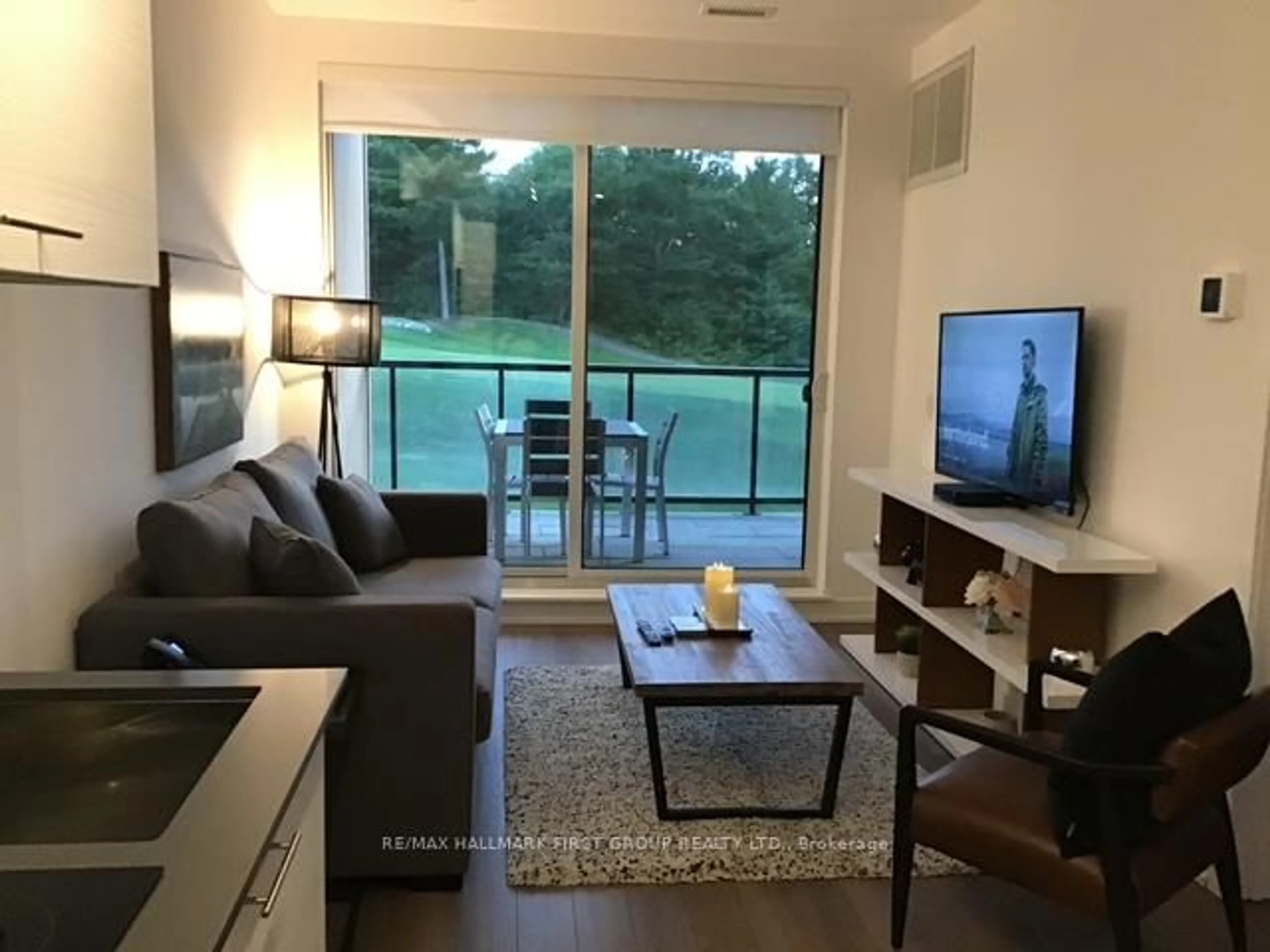 Living room with furniture, wood/laminate floor for 120 Carrick Tr #104, Gravenhurst Ontario P1P 0A2