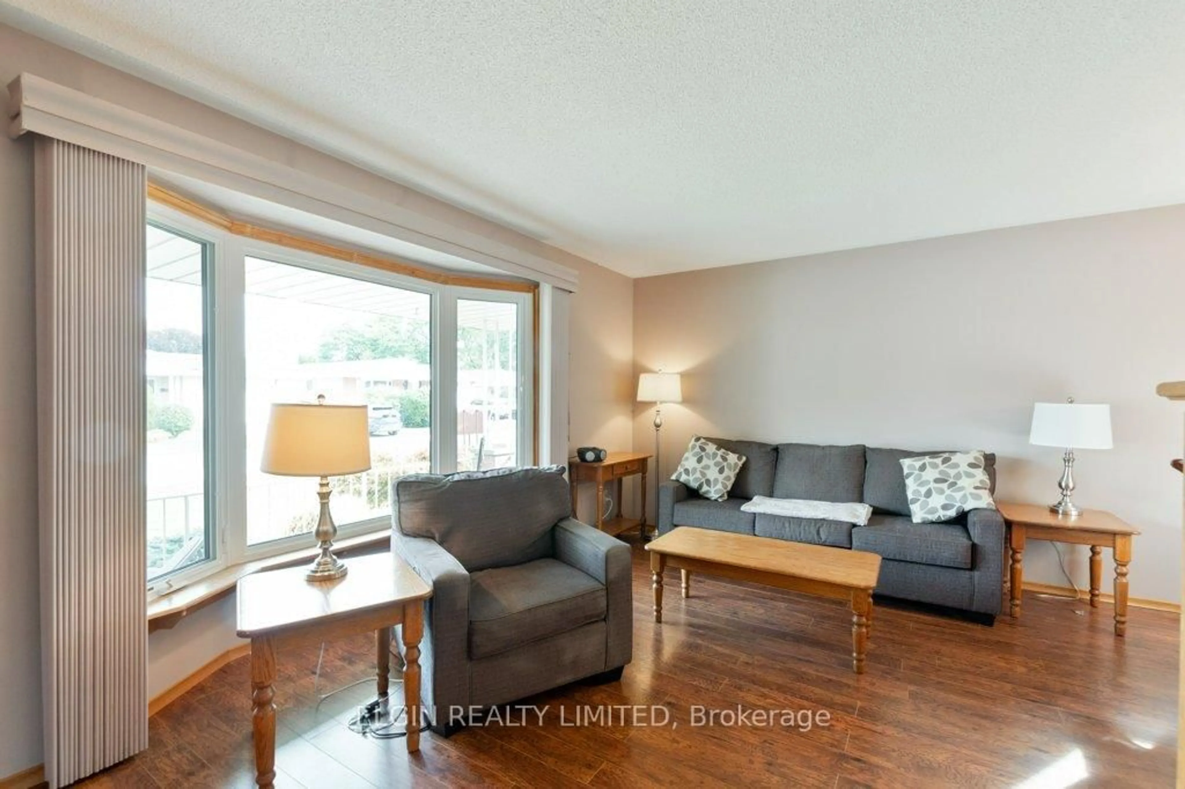 Living room with furniture, wood/laminate floor for 20 Farmington Dr, St. Thomas Ontario N5R 5X4