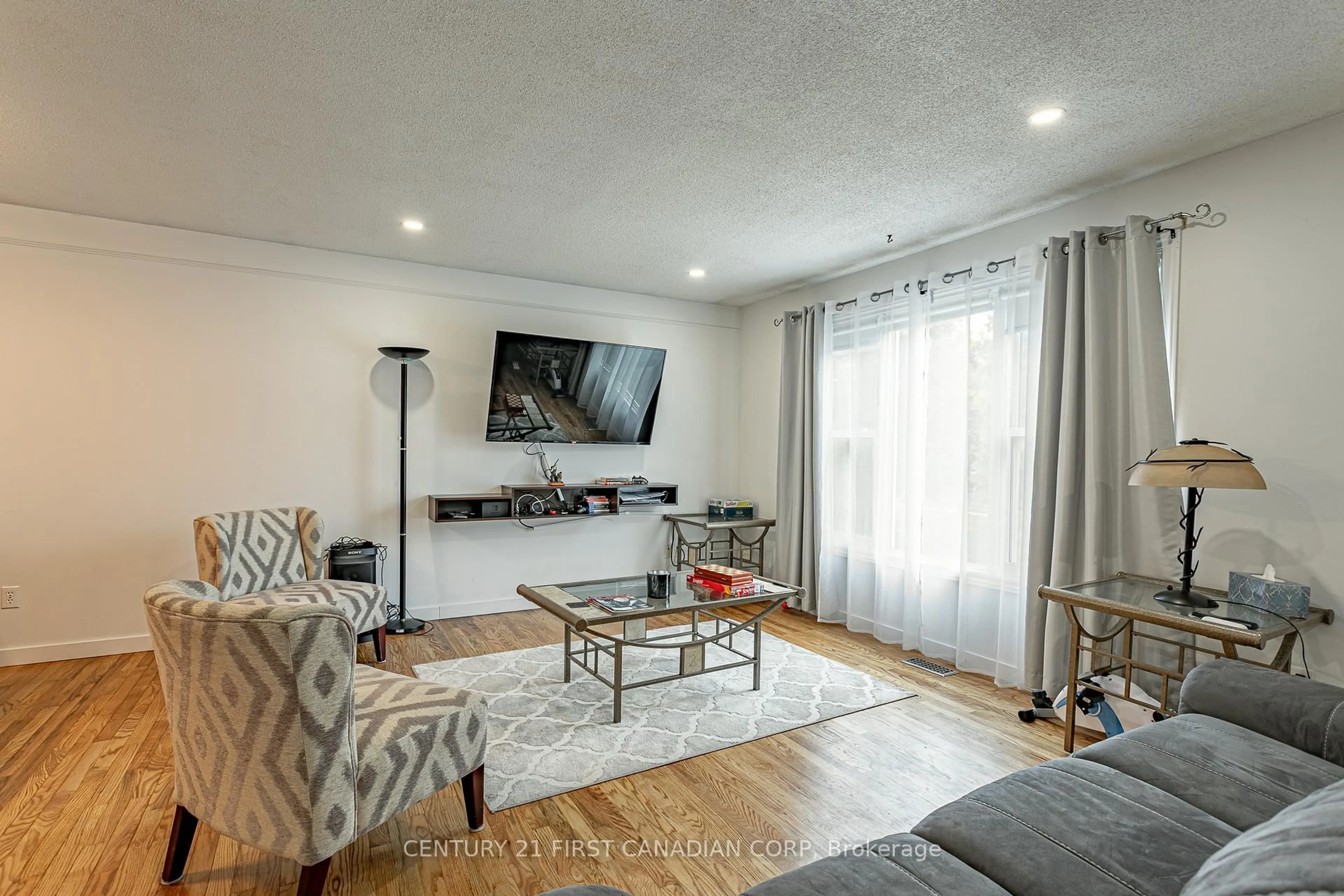 Living room with furniture, wood/laminate floor for 140 River Run Terr, London East Ontario N5W 5Z1