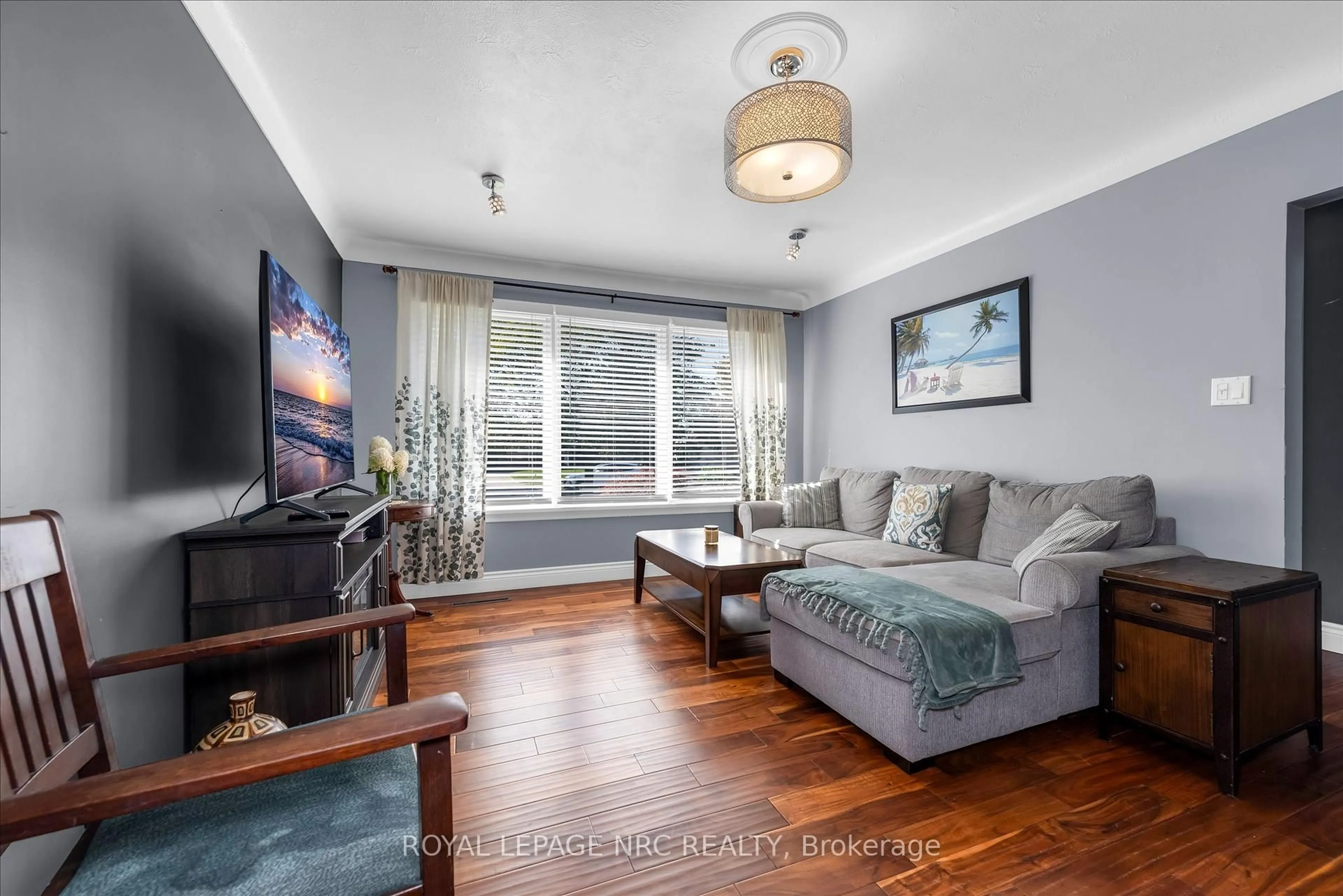 Living room with furniture, wood/laminate floor for 442 Bunting Rd, St. Catharines Ontario L2M 3Z4