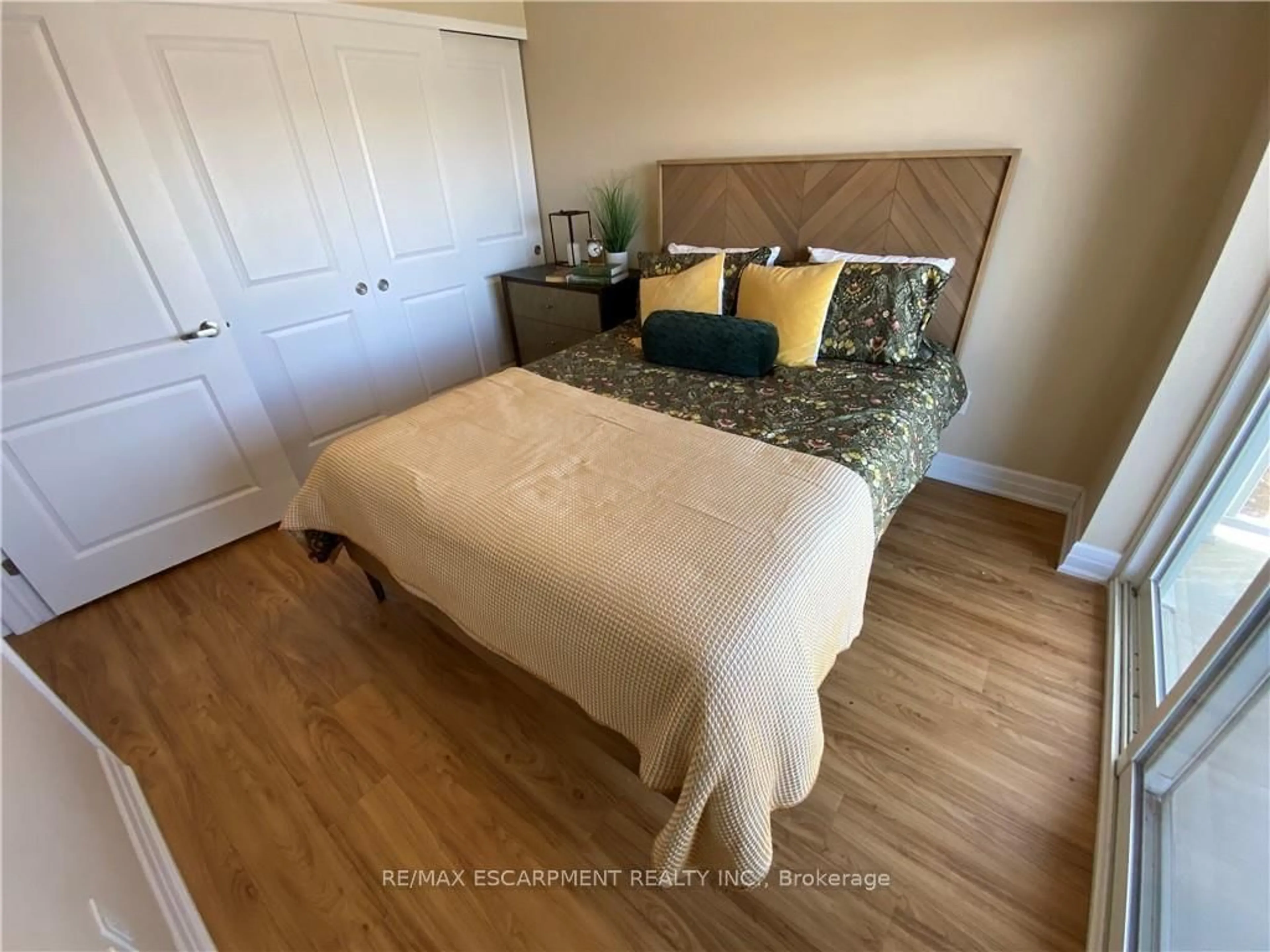 Bedroom with bed, wood/laminate floor for 39 SISTER VARGA Terr #115, Hamilton Ontario L9B 0J7