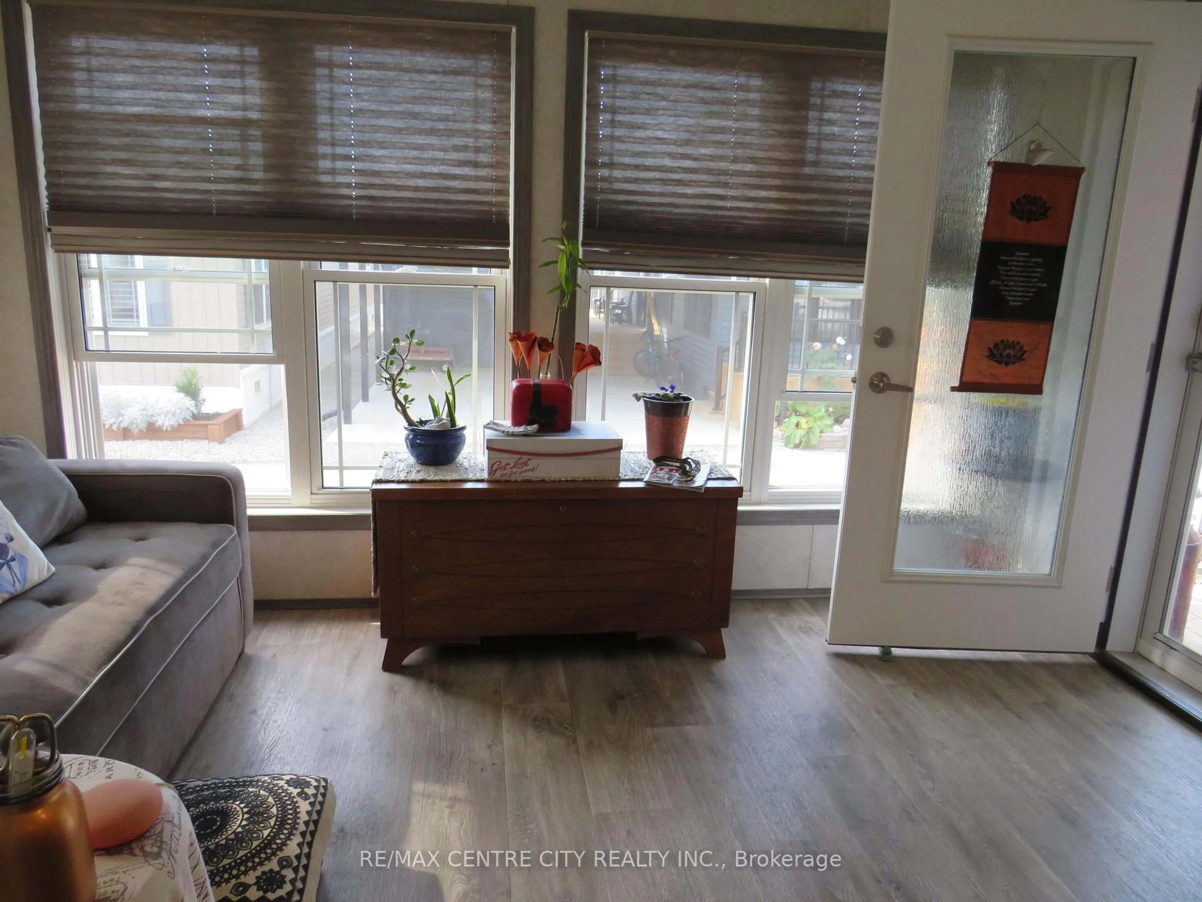 Living room with furniture, wood/laminate floor for 22790 Amiens Rd #116, Middlesex Centre Ontario N0L 1R0