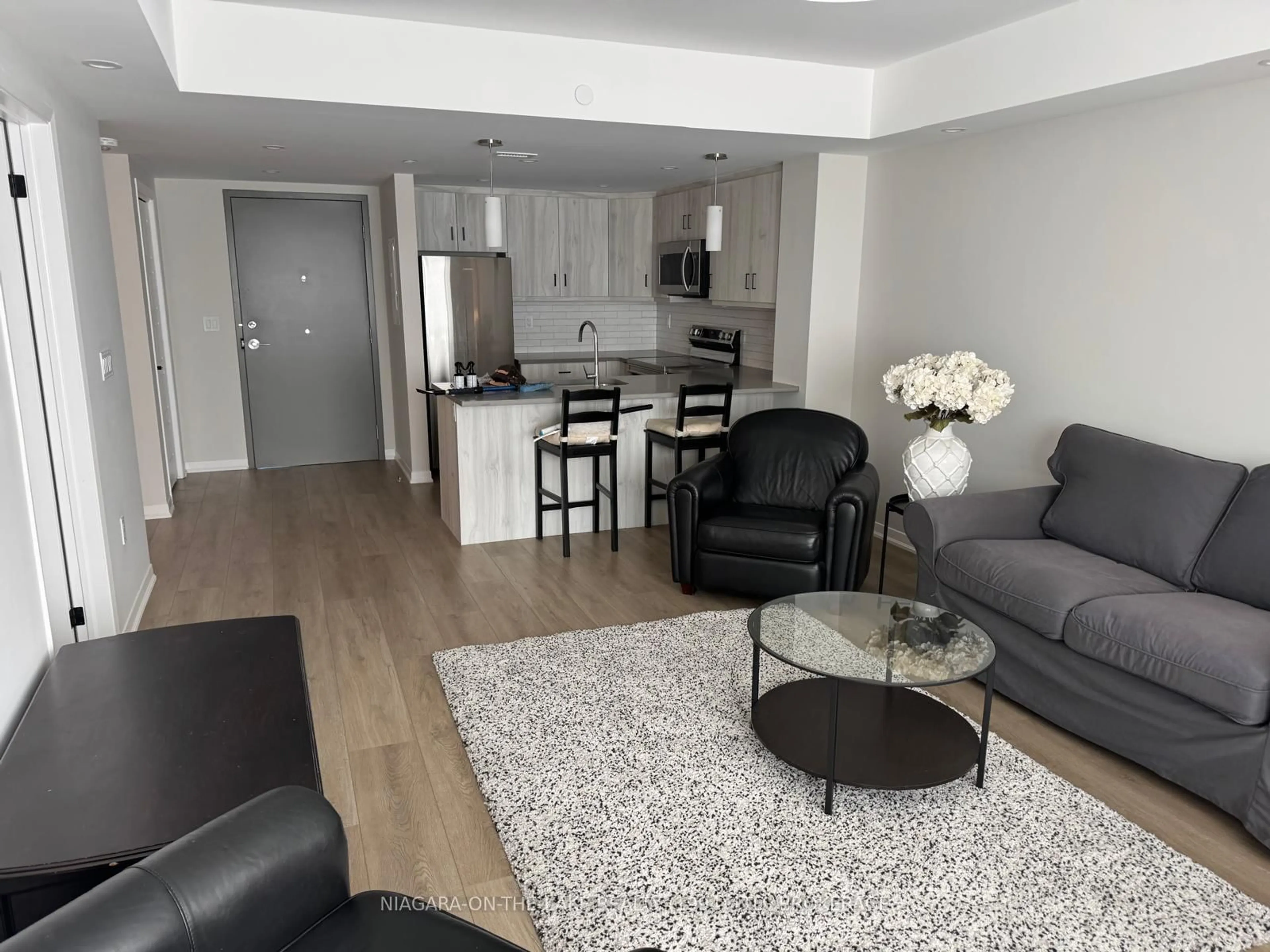 Living room with furniture, wood/laminate floor for 3998 Victoria Ave #206, Lincoln Ontario L0R 2C0