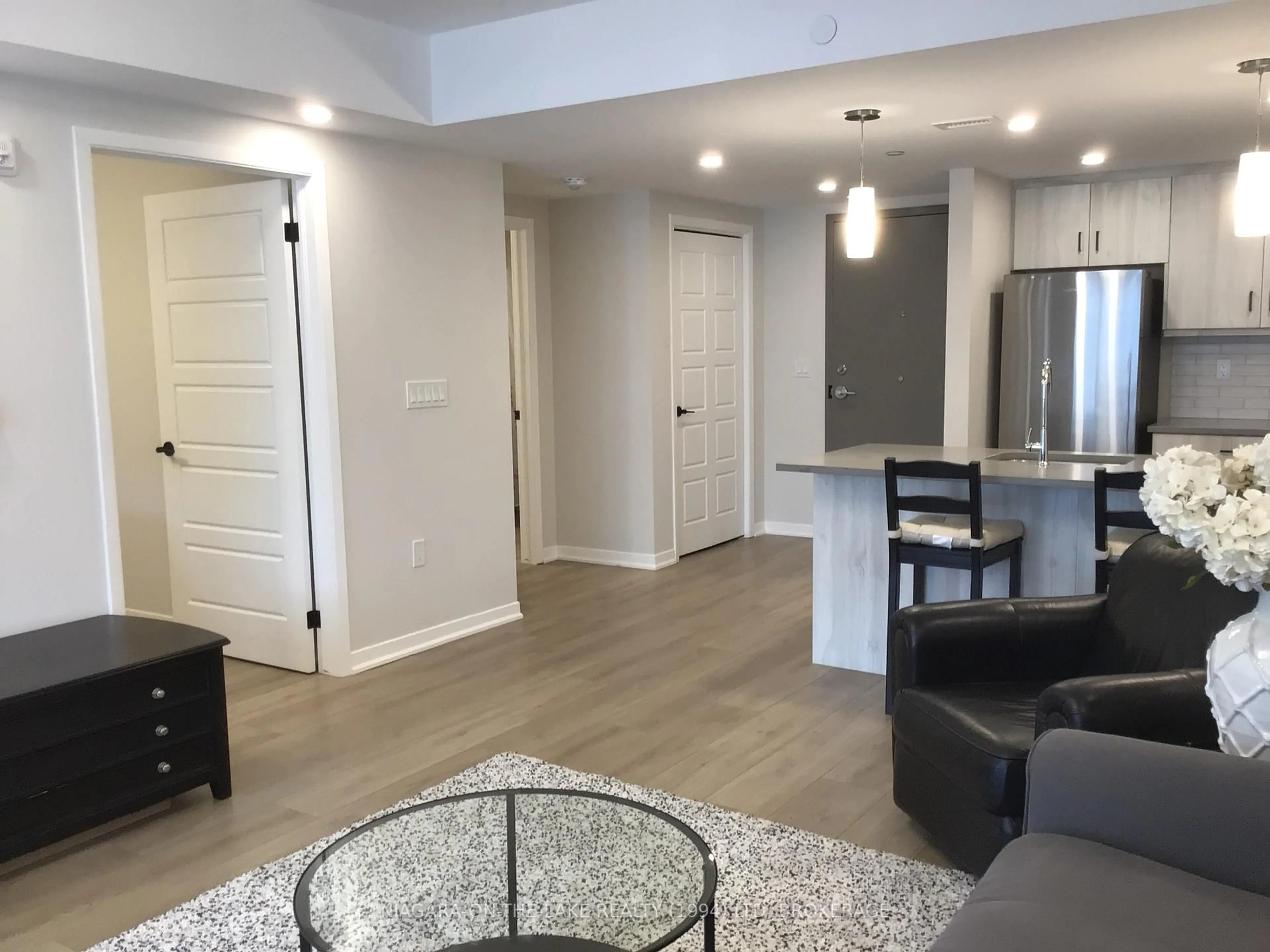 Living room with furniture, wood/laminate floor for 3998 Victoria Ave #206, Lincoln Ontario L0R 2C0