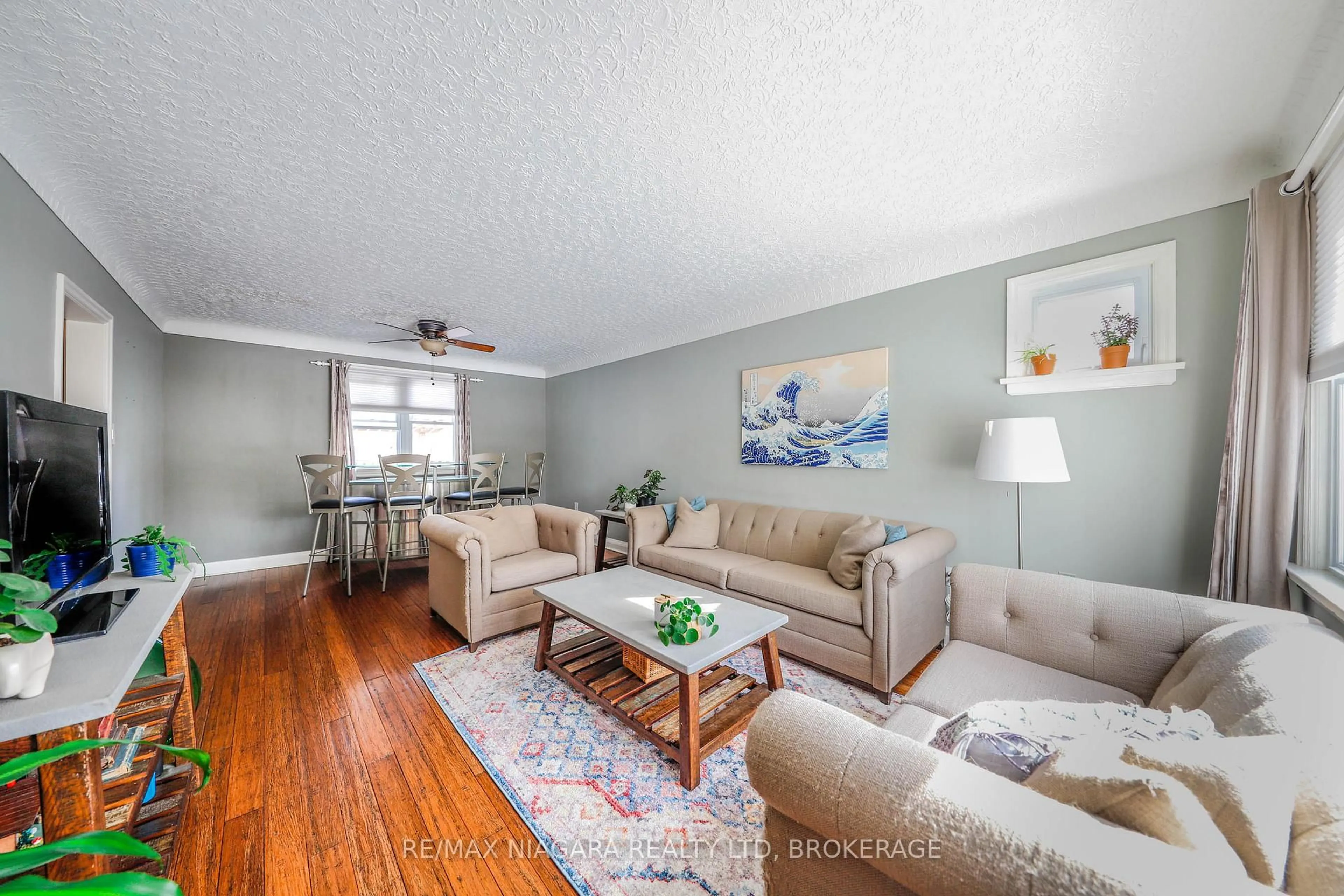Living room with furniture, wood/laminate floor for 82 Devon Rd, St. Catharines Ontario L2N 1X6