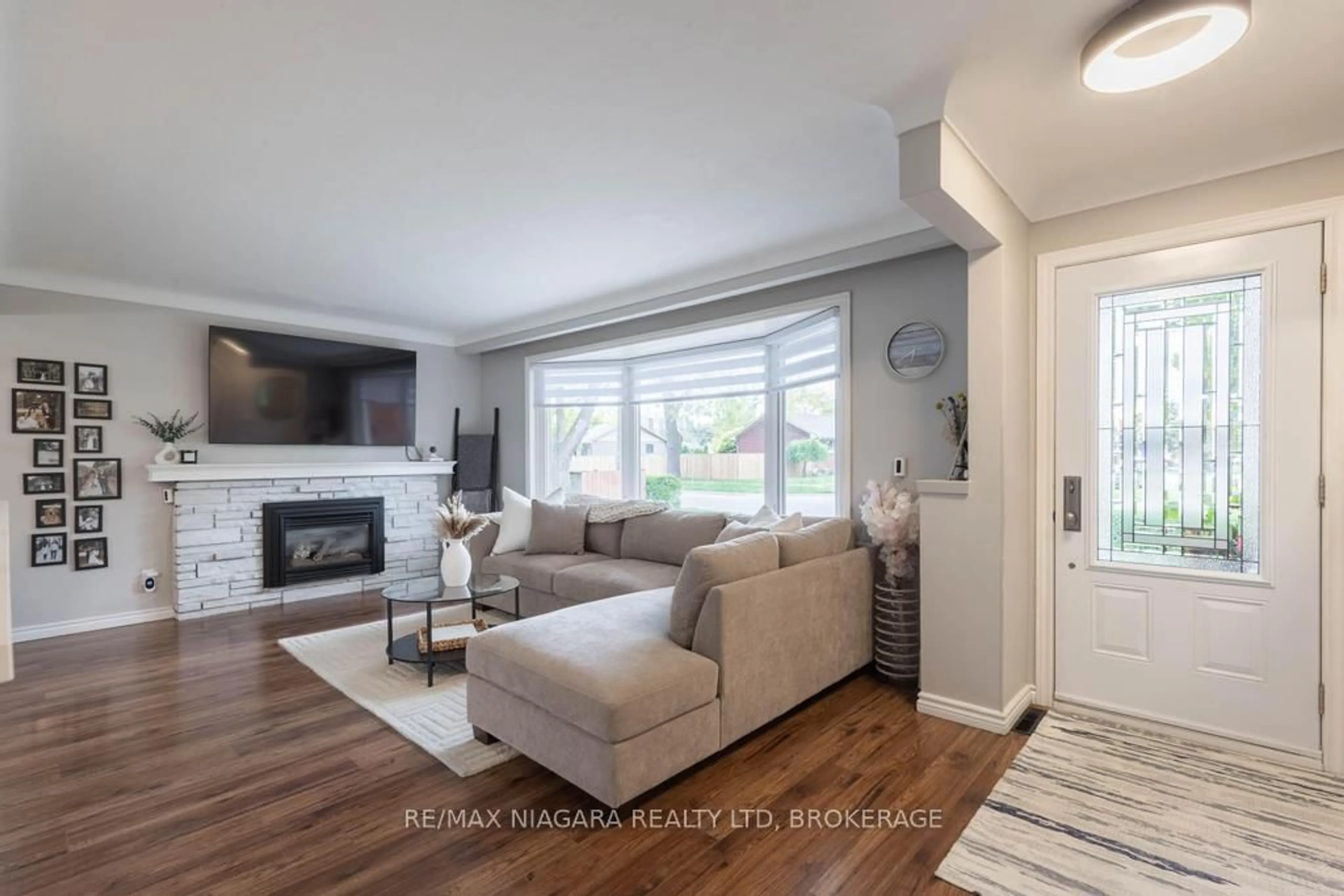 Living room with furniture, wood/laminate floor for 37 Parnell Rd, St. Catharines Ontario L2N 2W5
