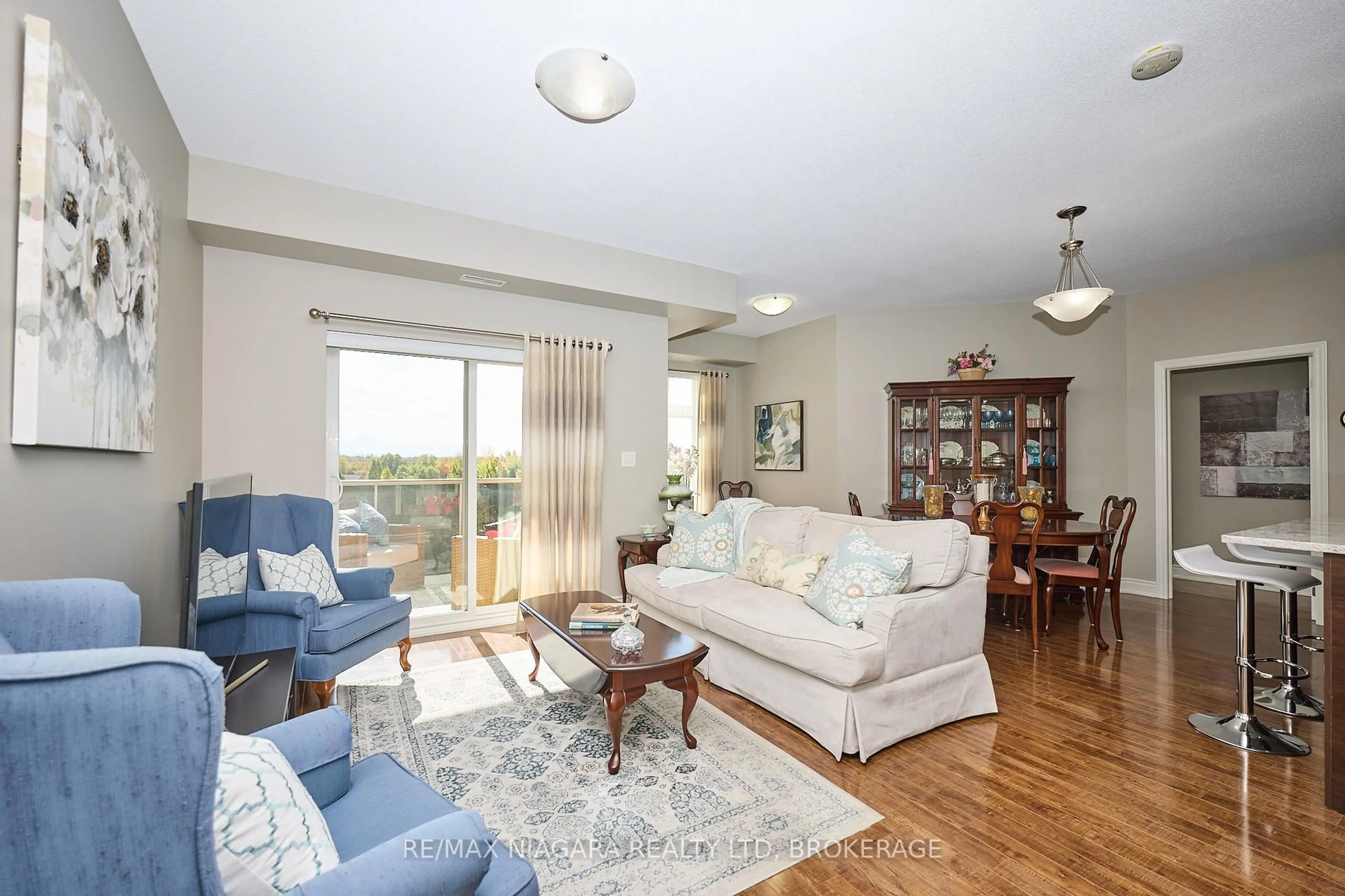 Living room with furniture, wood/laminate floor for 8111 Forest Glen Dr #427, Niagara Falls Ontario L2H 2Y7