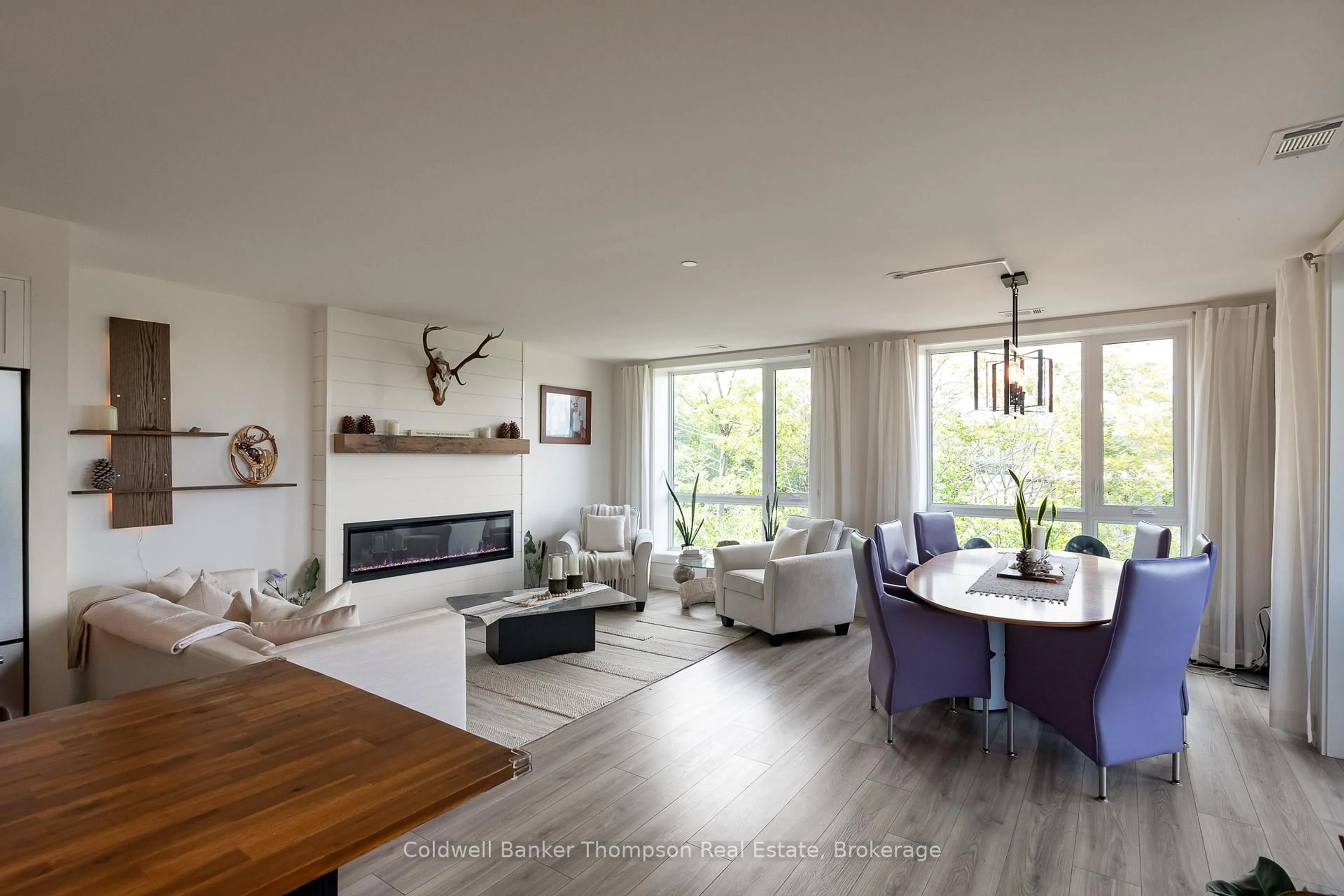 Living room with furniture, wood/laminate floor for 18 Campus Tr #403, Huntsville Ontario P1H 0K2