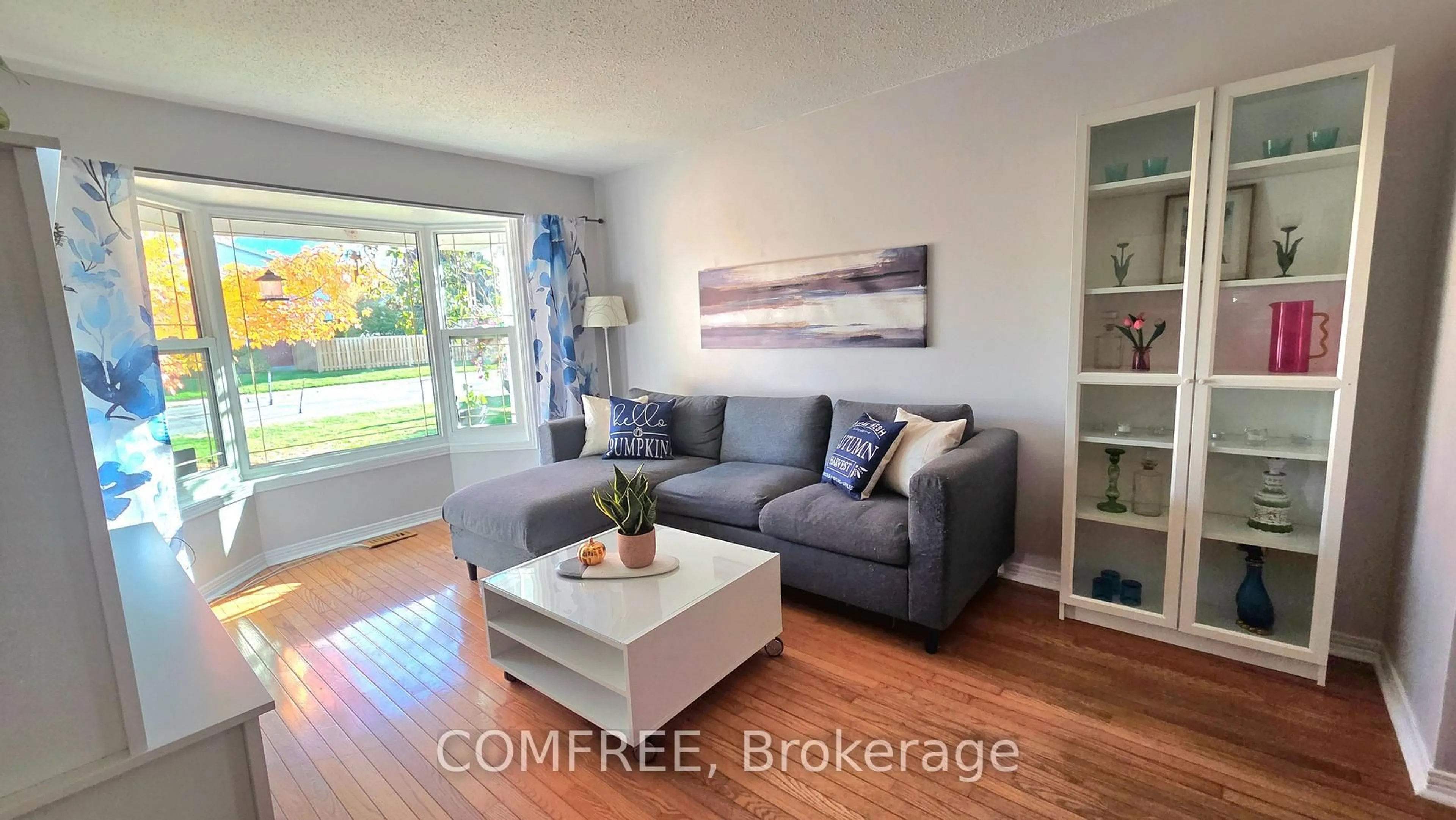 Living room with furniture, wood/laminate floor for 48 Tartan Dr, Barrhaven Ontario K2J 2V5