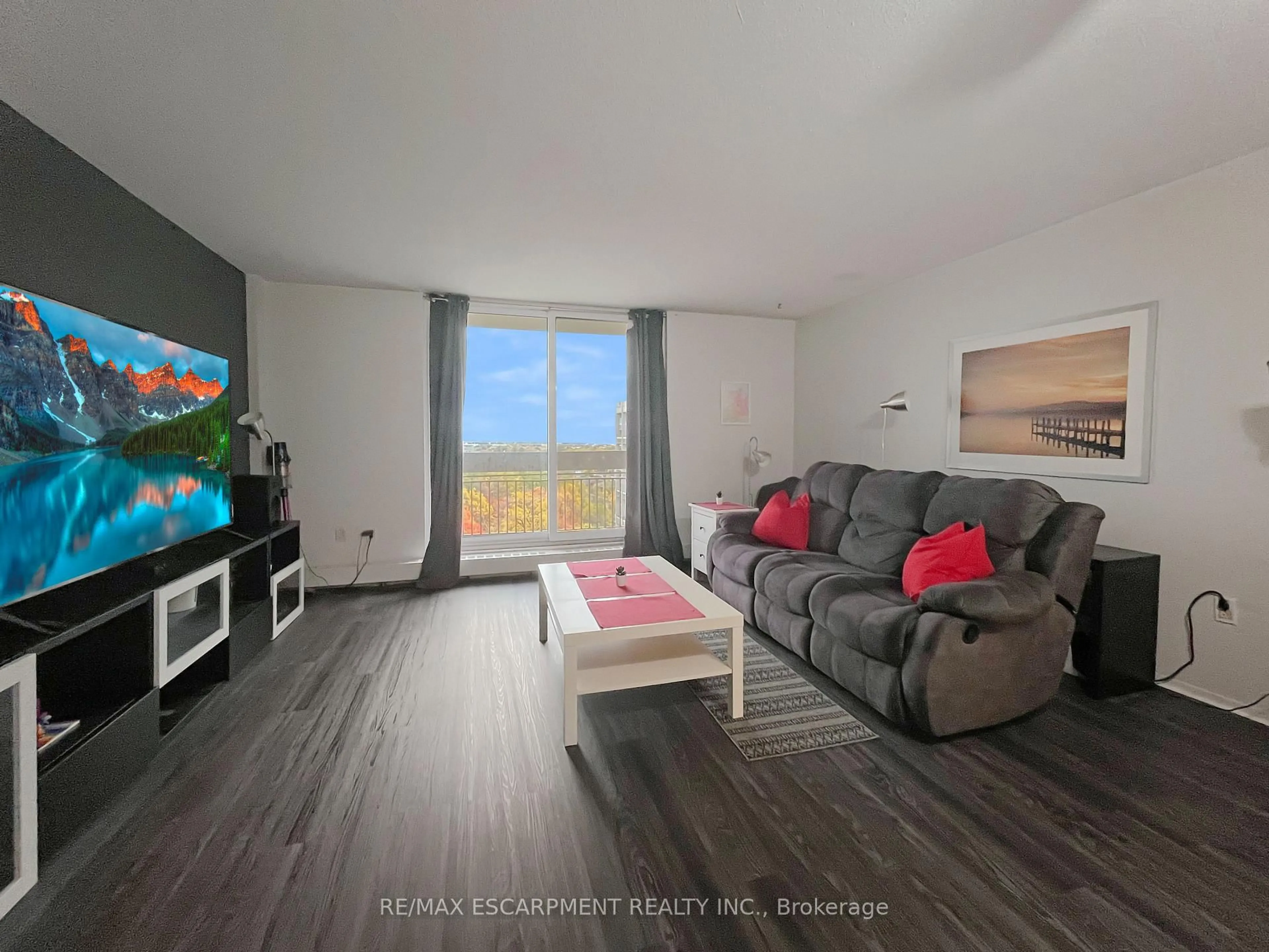 Living room with furniture, wood/laminate floor for 350 Quigley Rd #723, Hamilton Ontario L8K 5N2