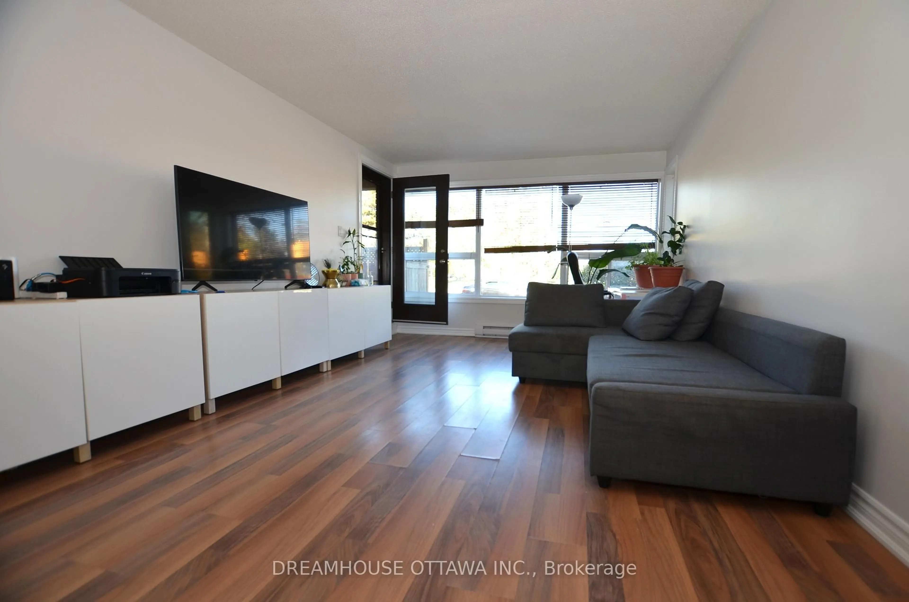 Living room with furniture, wood/laminate floor for 1490 Heron Rd #107, Ottawa Ontario K1V 6A5