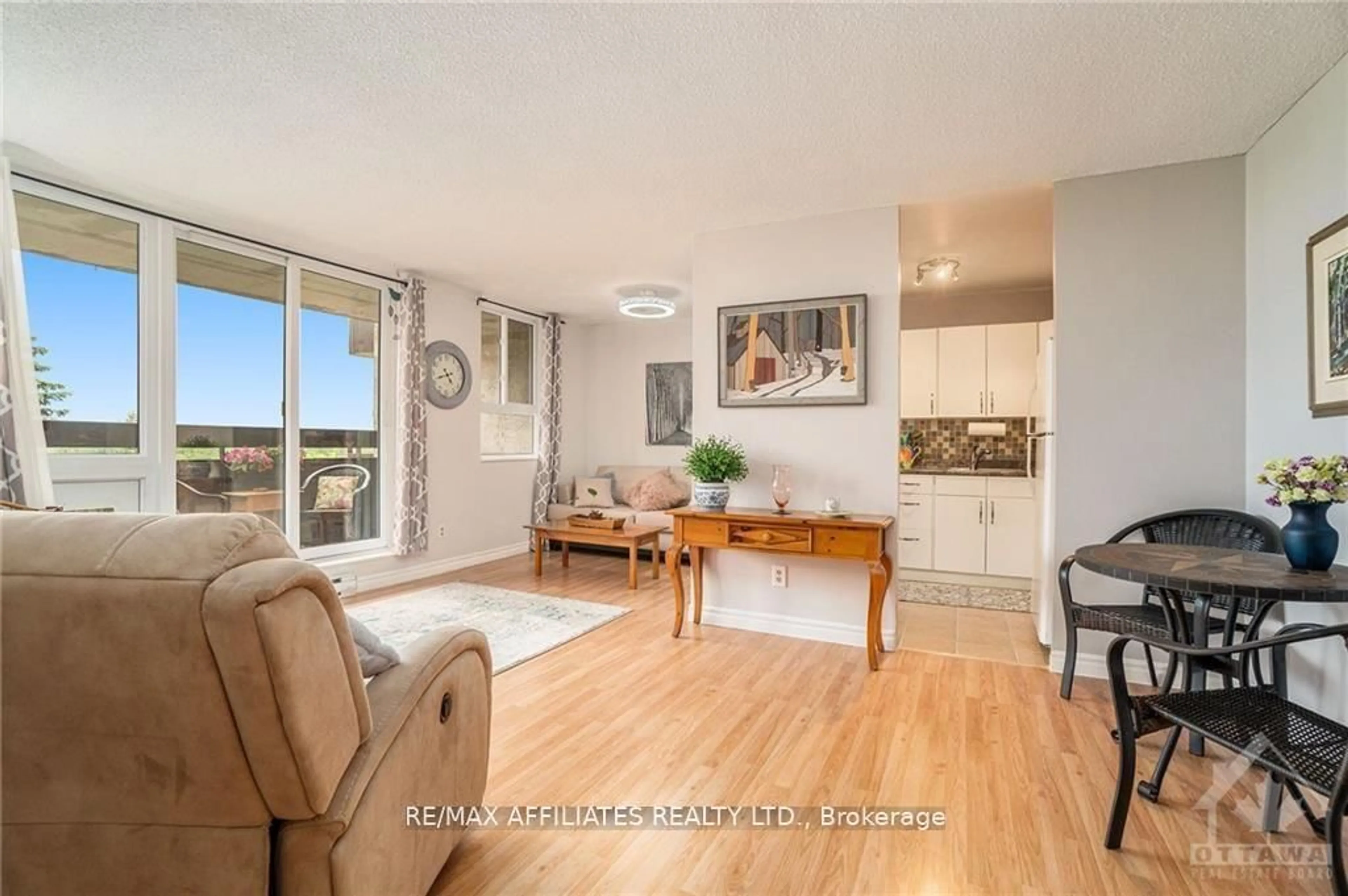 Living room with furniture, wood/laminate floor for 2000 Jasmine Cres #717, Ottawa Ontario K1J 8K4