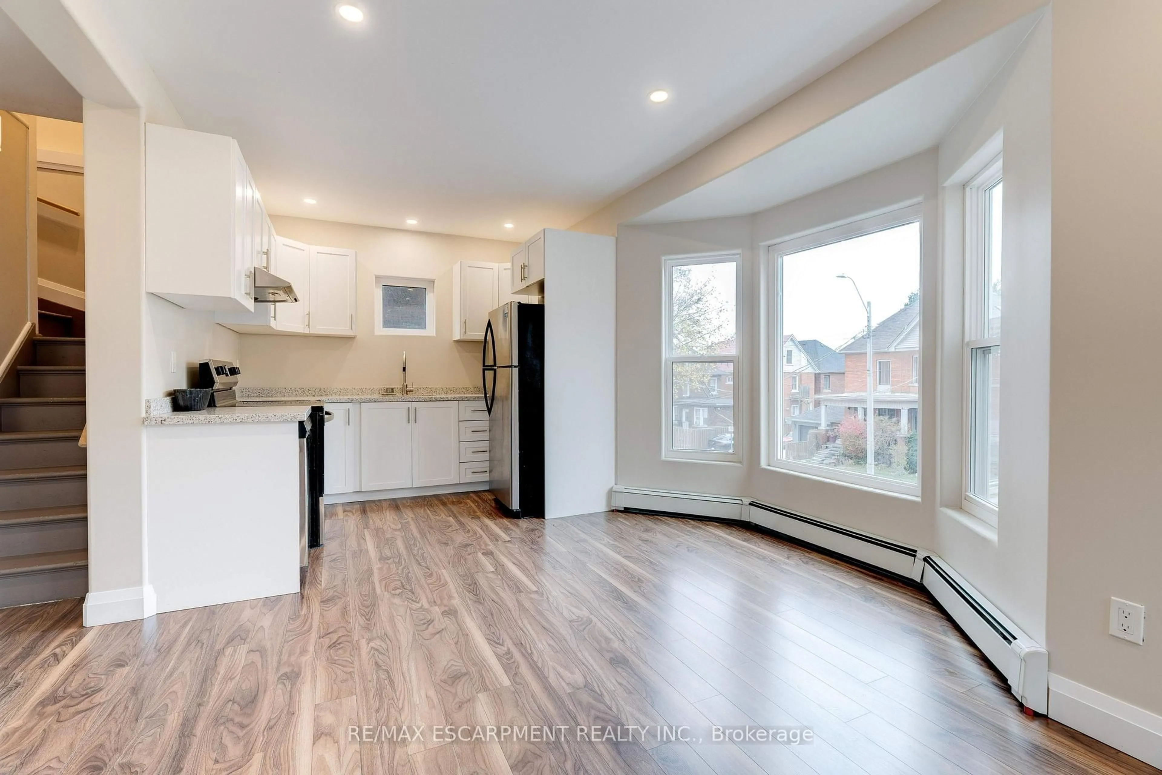 Open concept kitchen, wood/laminate floor for 152 Sanford Ave, Hamilton Ontario L8M 2G9