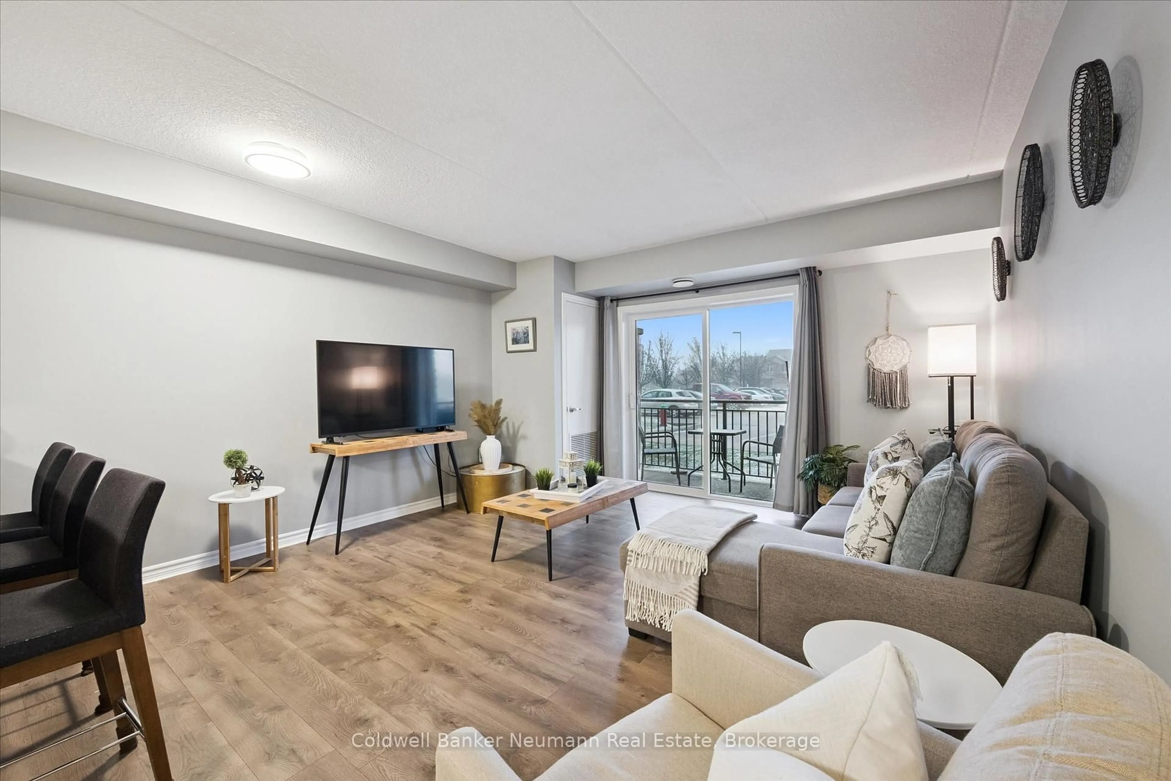 Living room with furniture, wood/laminate floor for 19 Waterford Dr #109, Guelph Ontario N1L 0G8