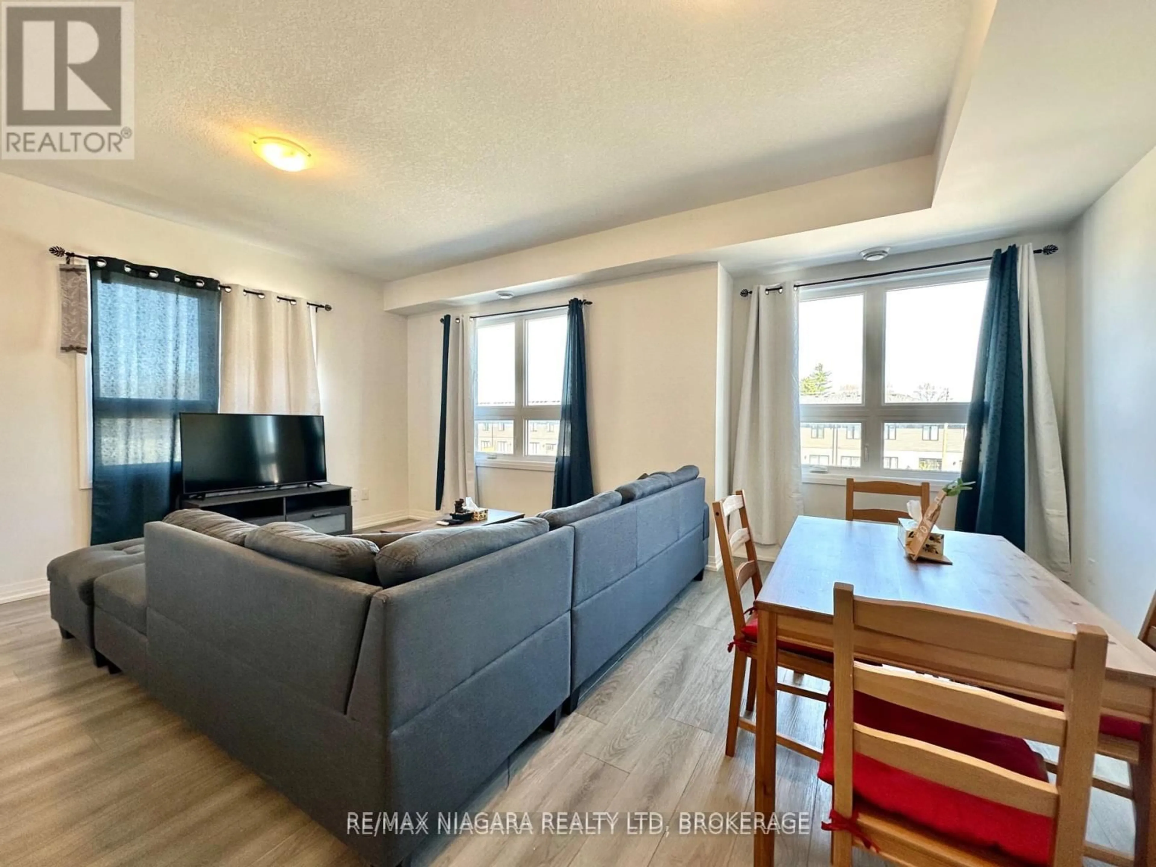 Living room with furniture, wood/laminate floor for 6705 Cropp St #43, Niagara Falls Ontario L2E 0C1