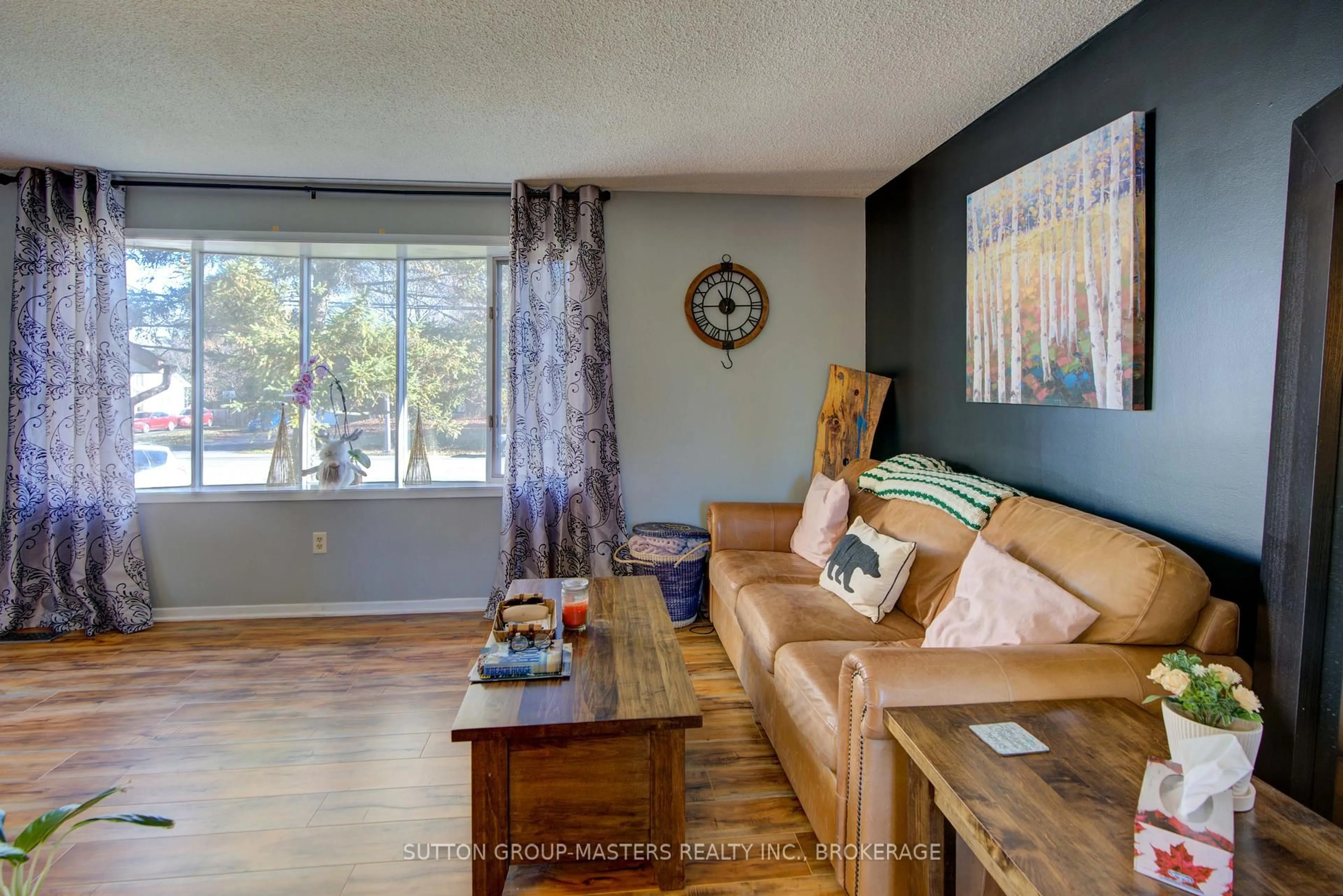 Living room with furniture, wood/laminate floor for 715 Collins Bay Rd, Kingston Ontario K7M 5H1