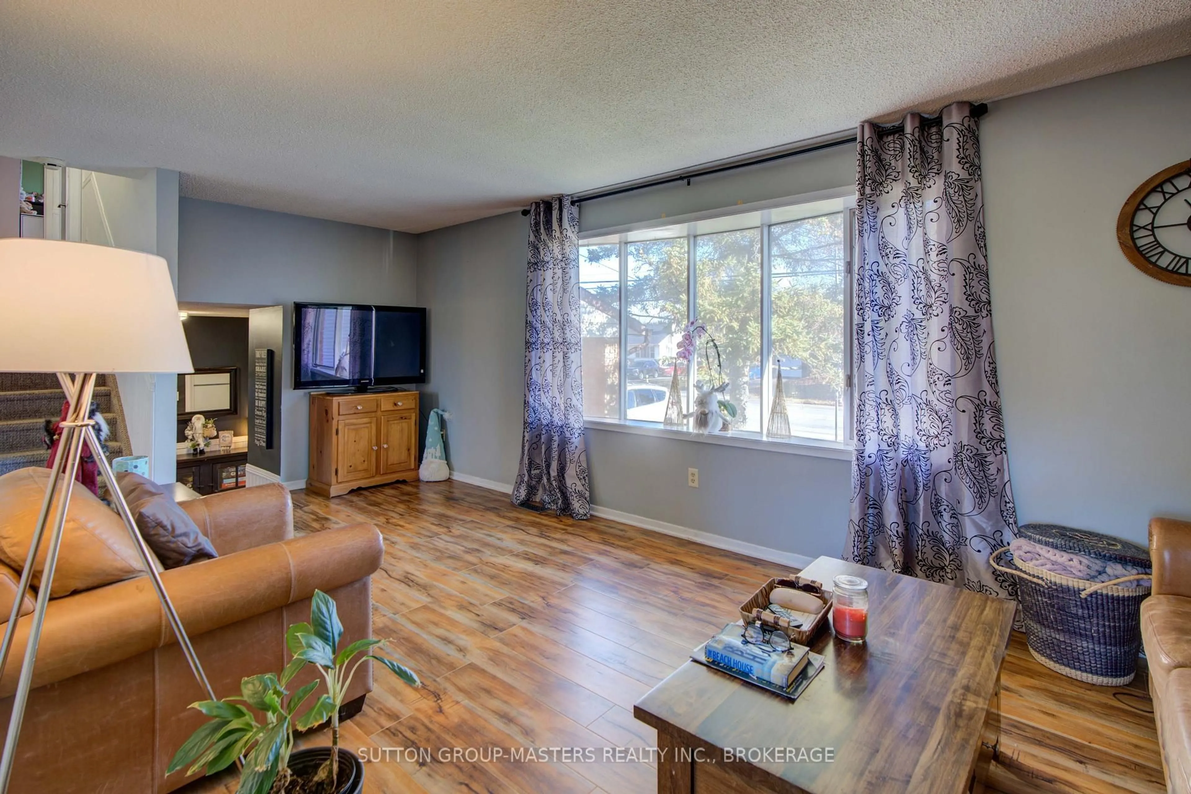 Living room with furniture, wood/laminate floor for 715 Collins Bay Rd, Kingston Ontario K7M 5H1