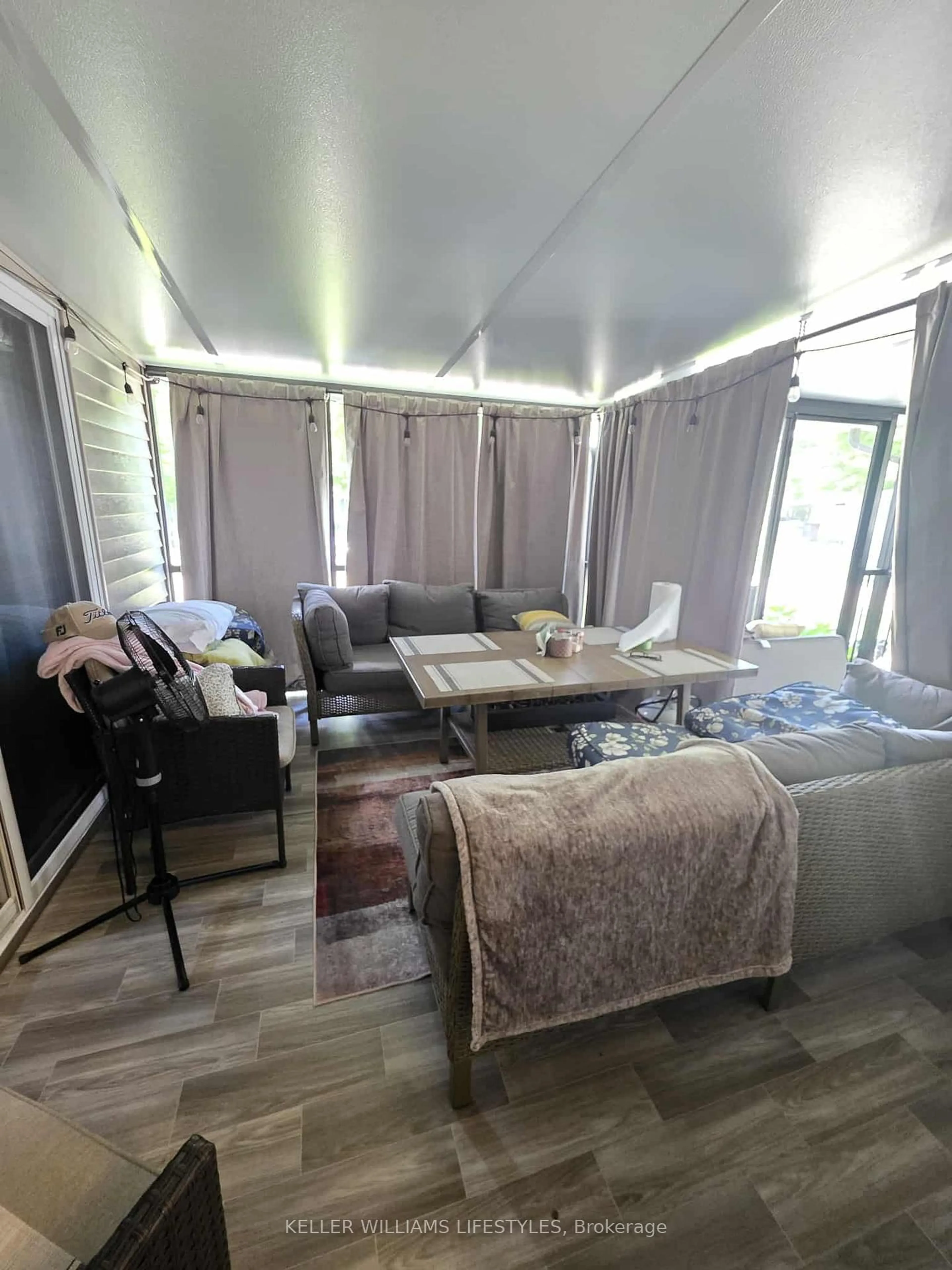 Living room with furniture, wood/laminate floor for 9338 West Ipperwash Rd #JJ22, Lambton Shores Ontario N0N 1J2