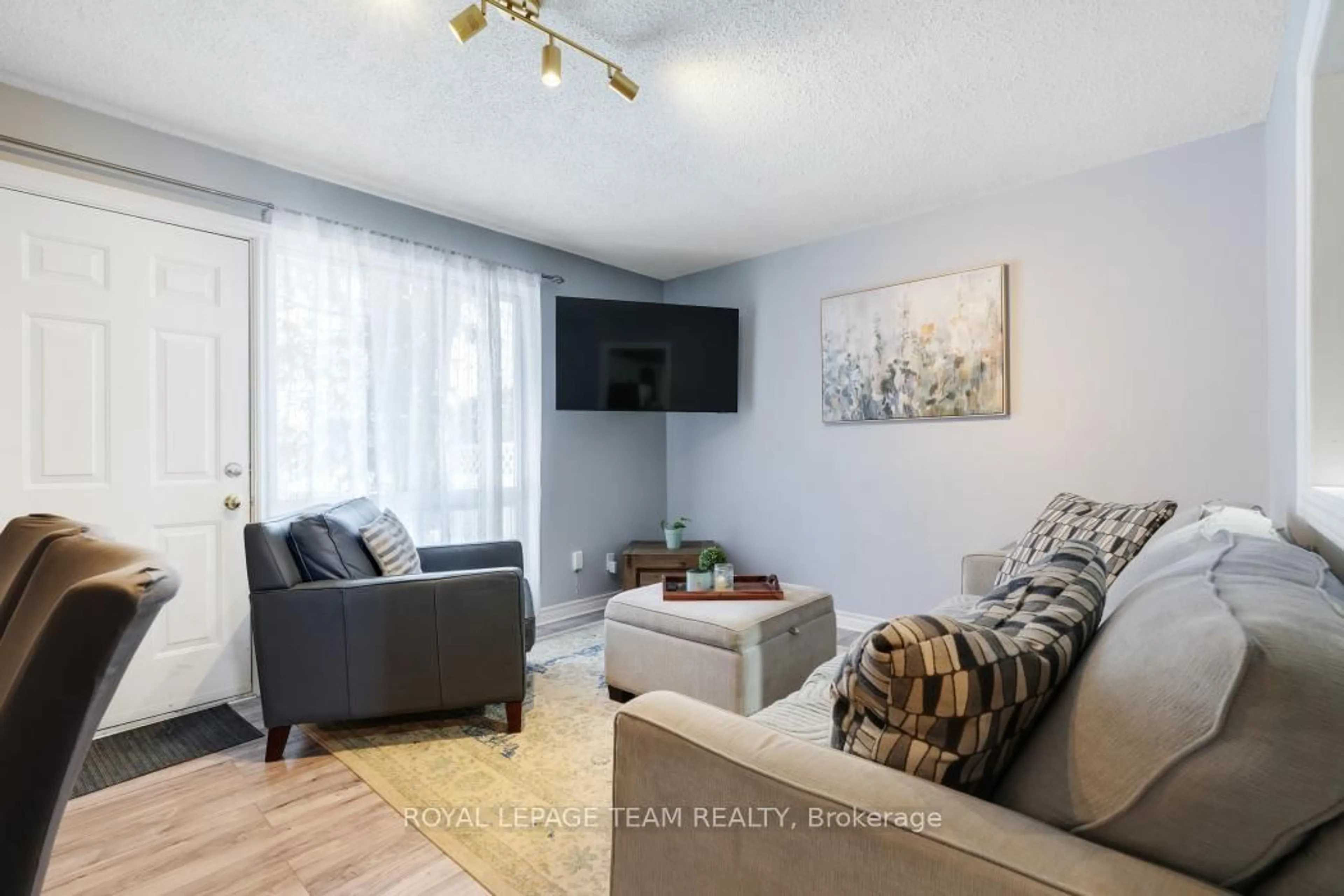 Living room with furniture, wood/laminate floor for 52 Alison Korn Private, Ottawa Ontario K2H 8M6