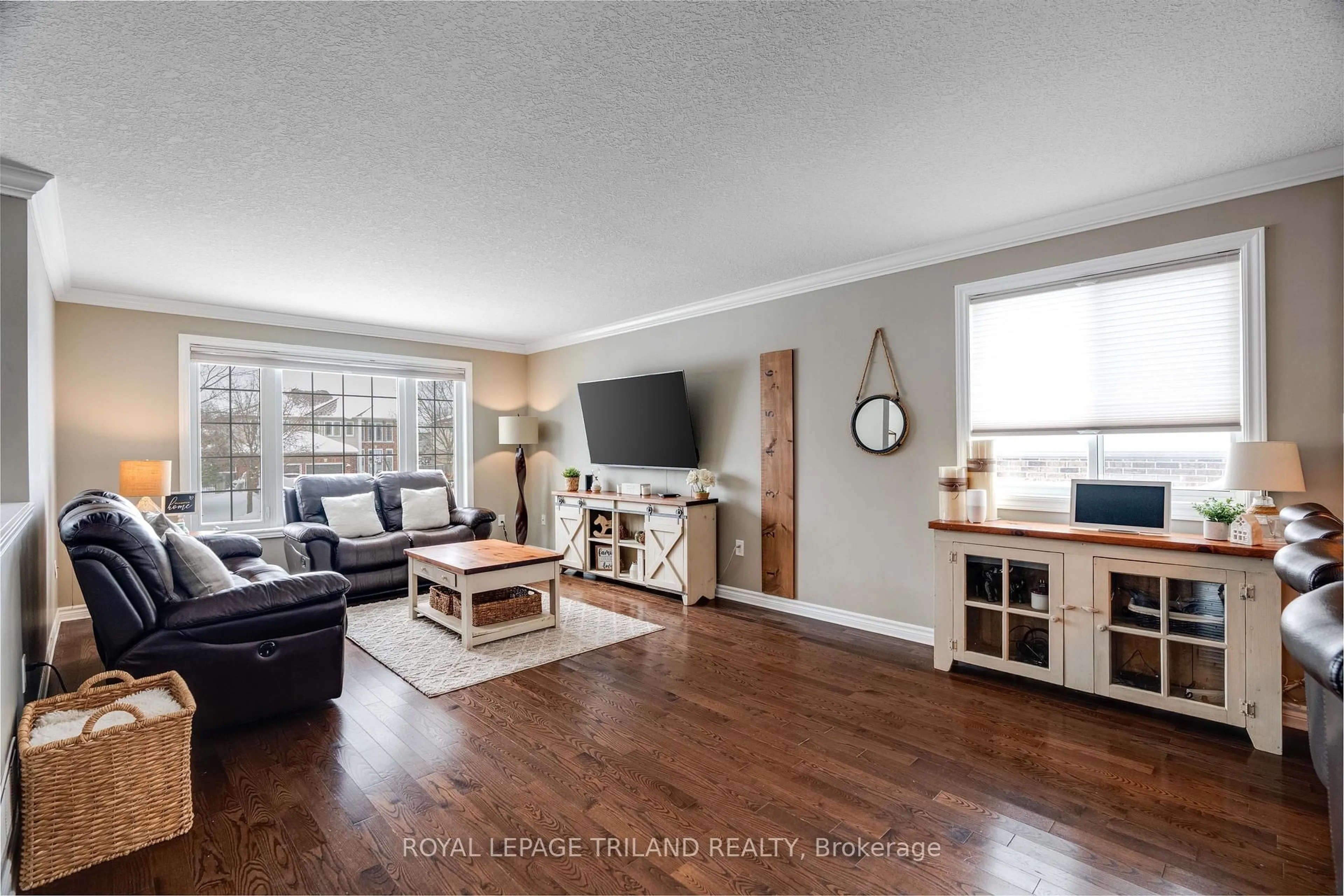 Living room with furniture, wood/laminate floor for 42 Fieldstone Cres, Middlesex Centre Ontario N0L 1R0