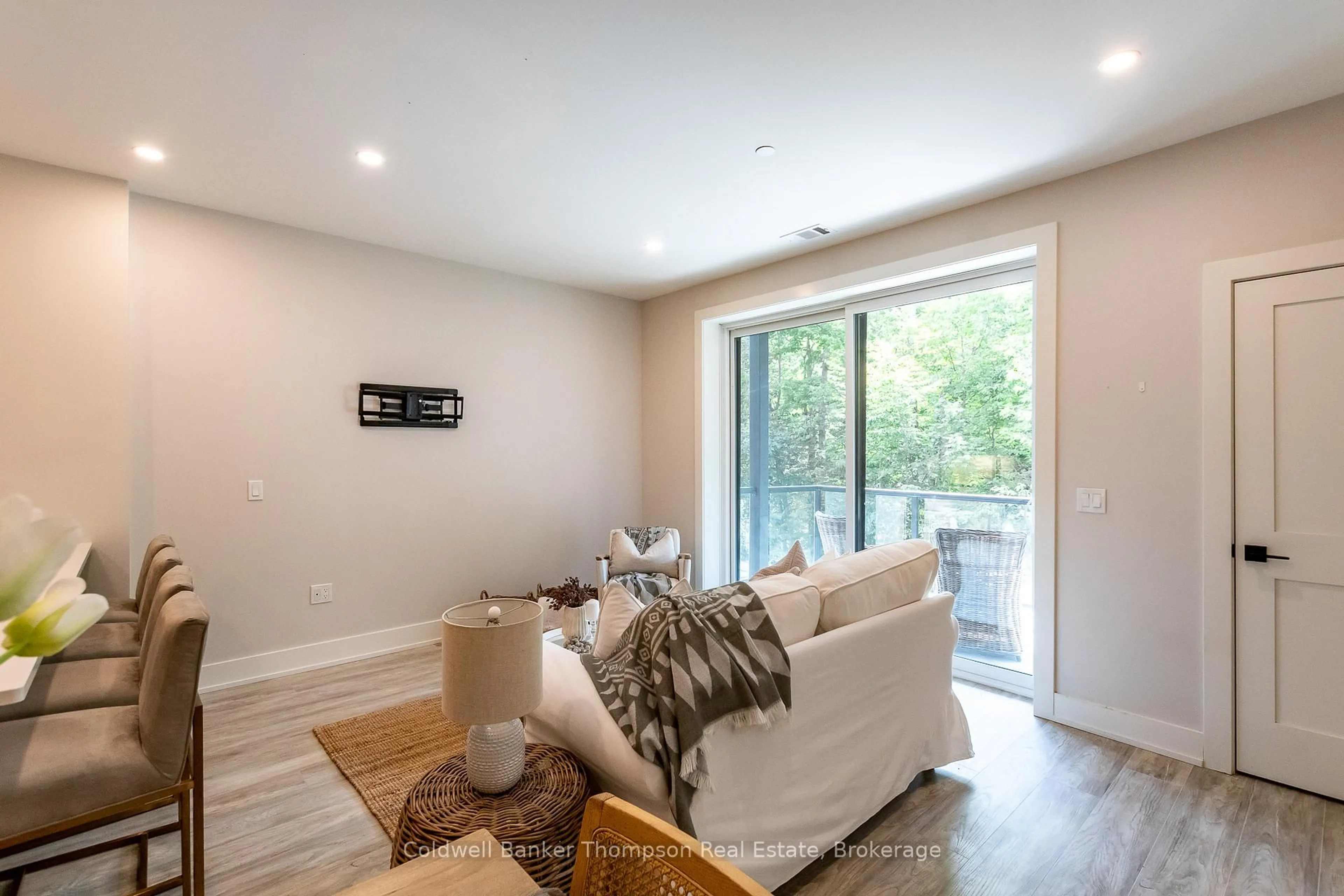 Living room with furniture, wood/laminate floor for 18 Campus Tr #207, Huntsville Ontario P1H 0K2