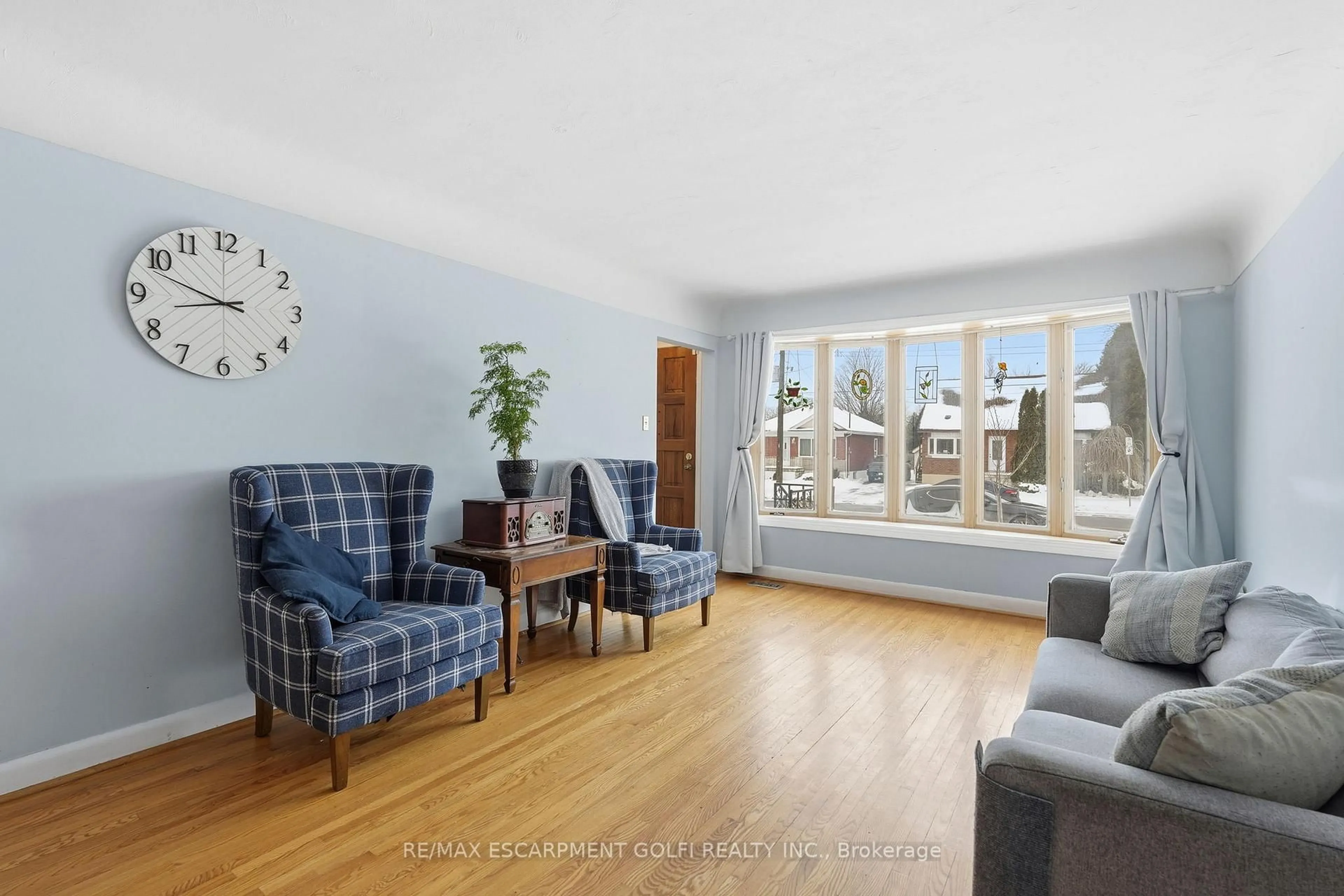 Living room with furniture, wood/laminate floor for 940 Brucedale Ave, Hamilton Ontario L8T 1L9