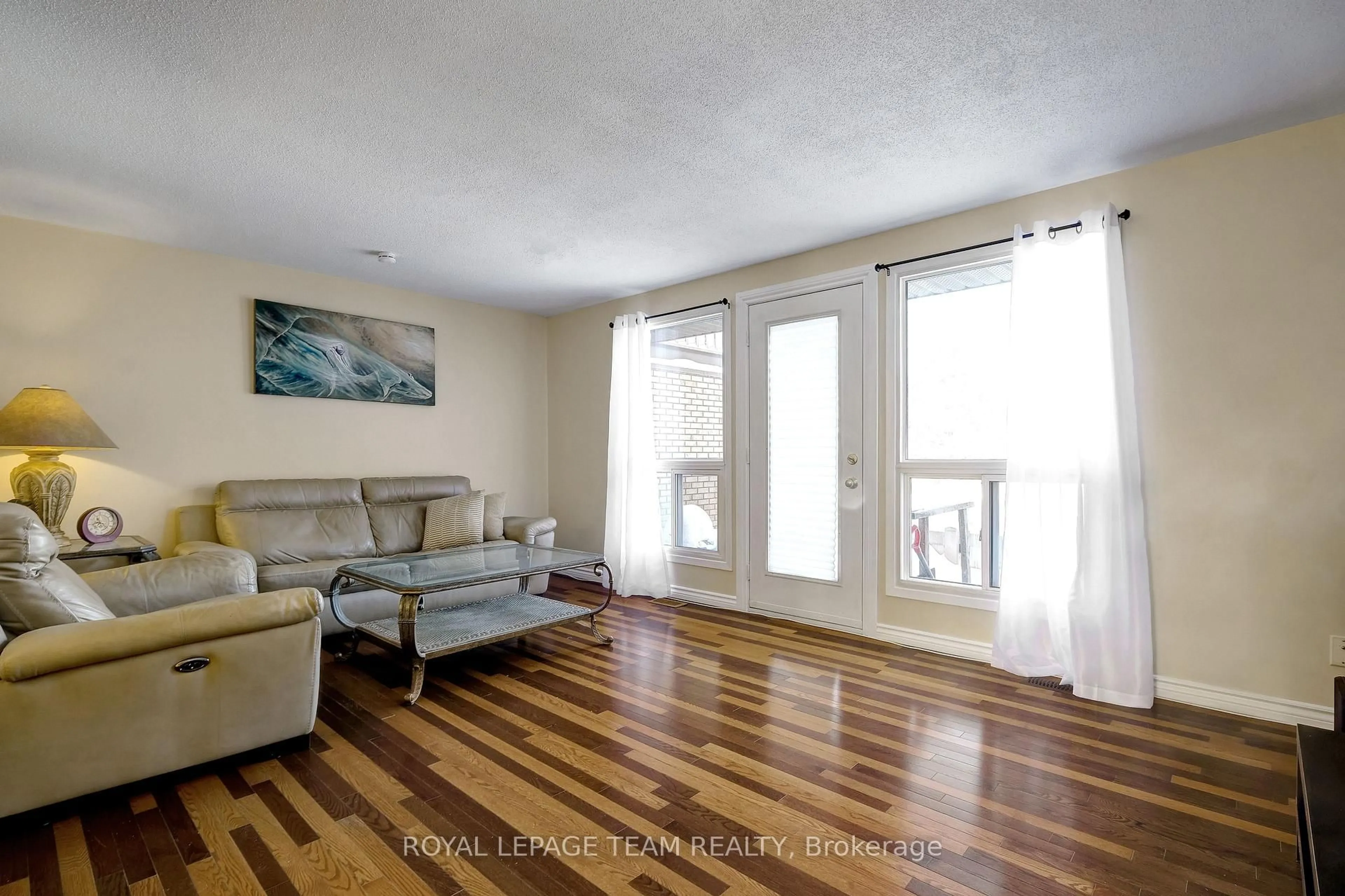 Living room with furniture, wood/laminate floor for 2027 Stonehenge Cres #35, Ottawa Ontario K1B 4N7