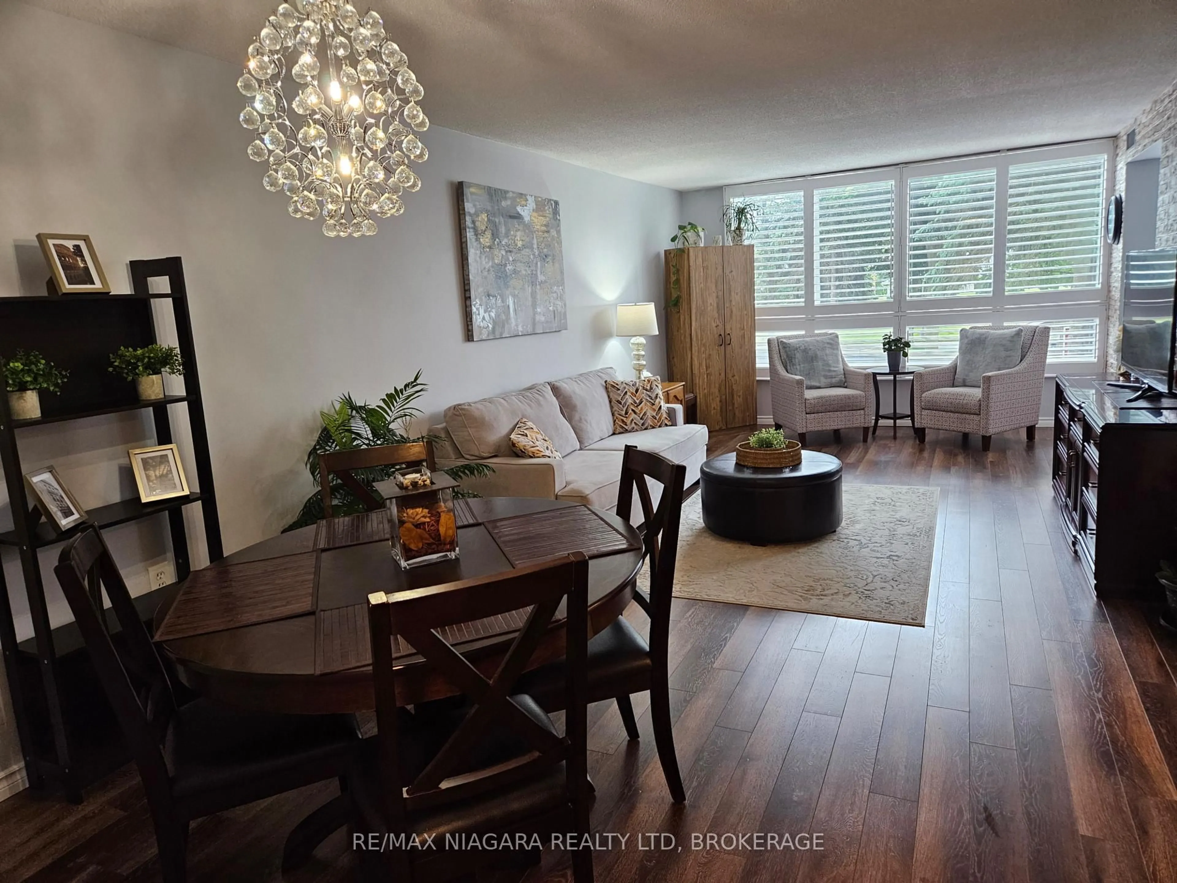 Living room with furniture, wood/laminate floor for 5100 Dorchester Rd #210, Niagara Falls Ontario L2E 7H4