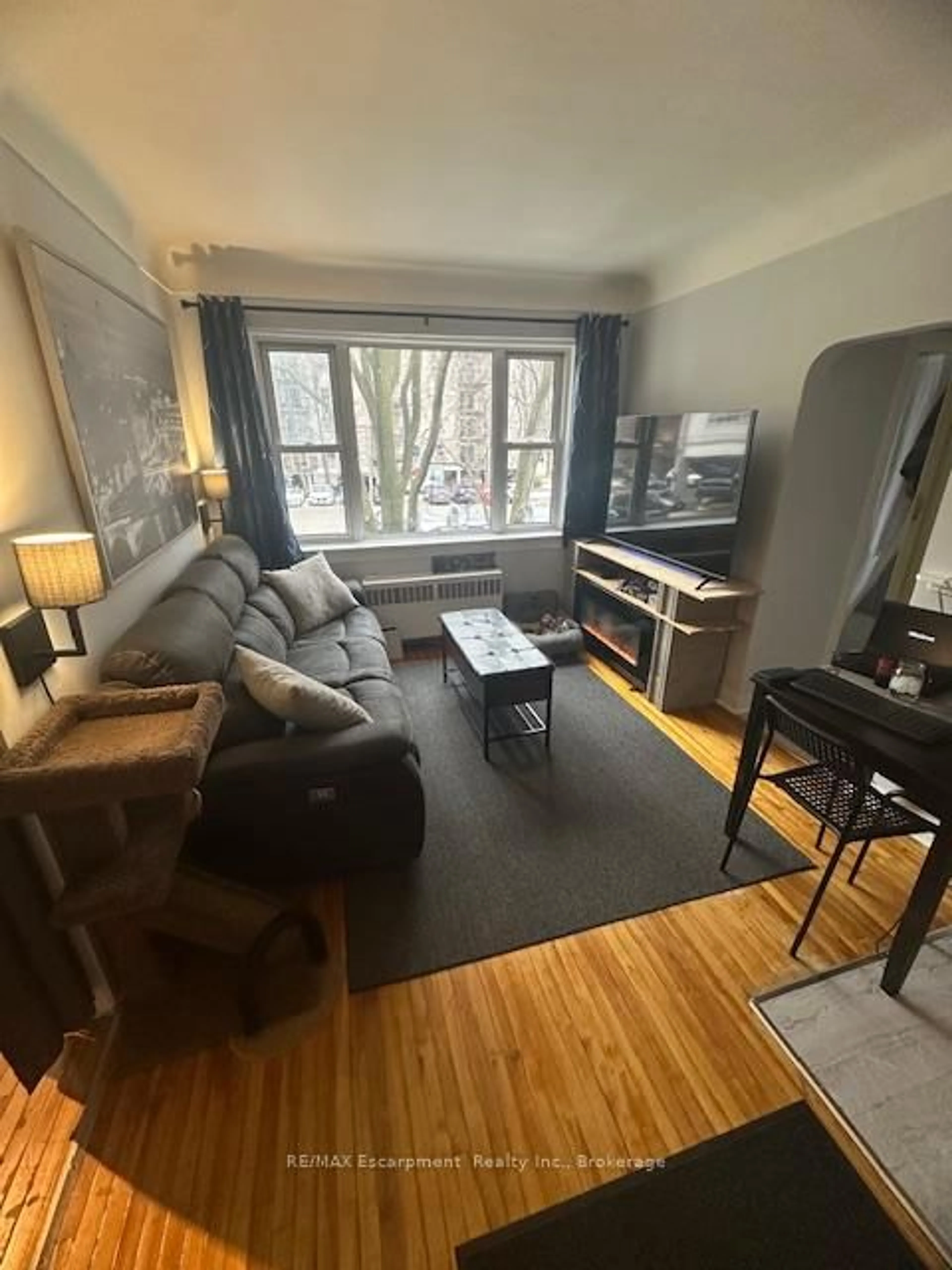 Living room with furniture, wood/laminate floor for 60 Robinson St #305, Hamilton Ontario L8P 1Y9