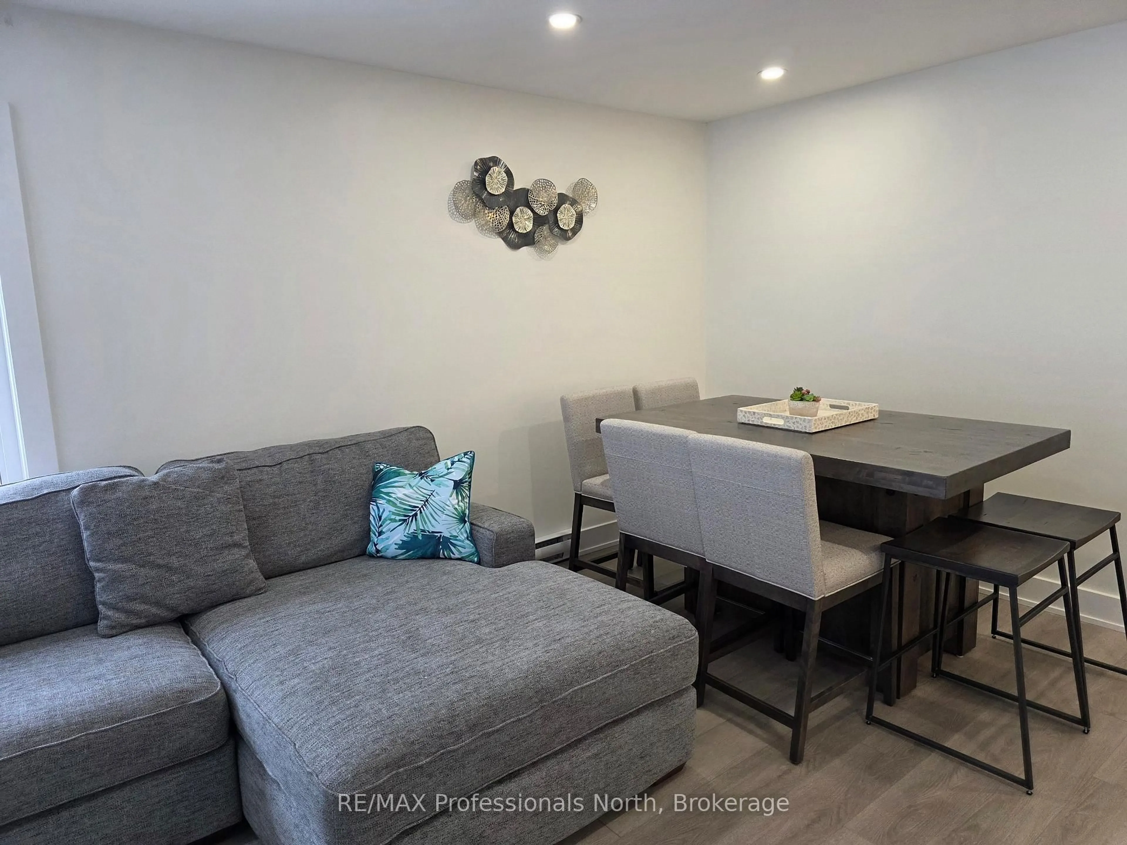 Living room with furniture, wood/laminate floor for 32 Deerhurst Greens Dr #105, Huntsville Ontario P1H 2E8