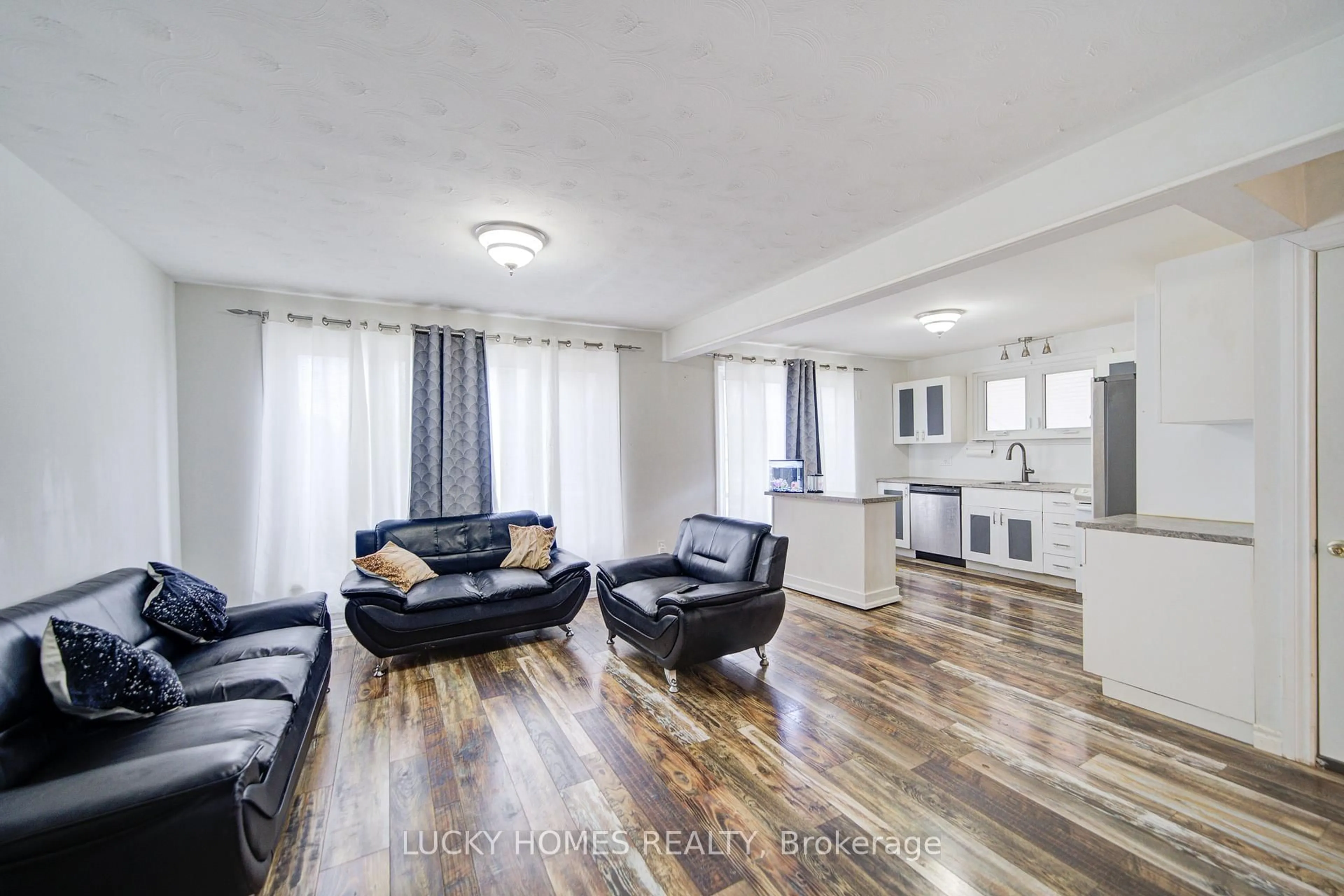 Living room with furniture, wood/laminate floor for 711 Otonabee Dr, Peterborough Ontario M1B 6B2