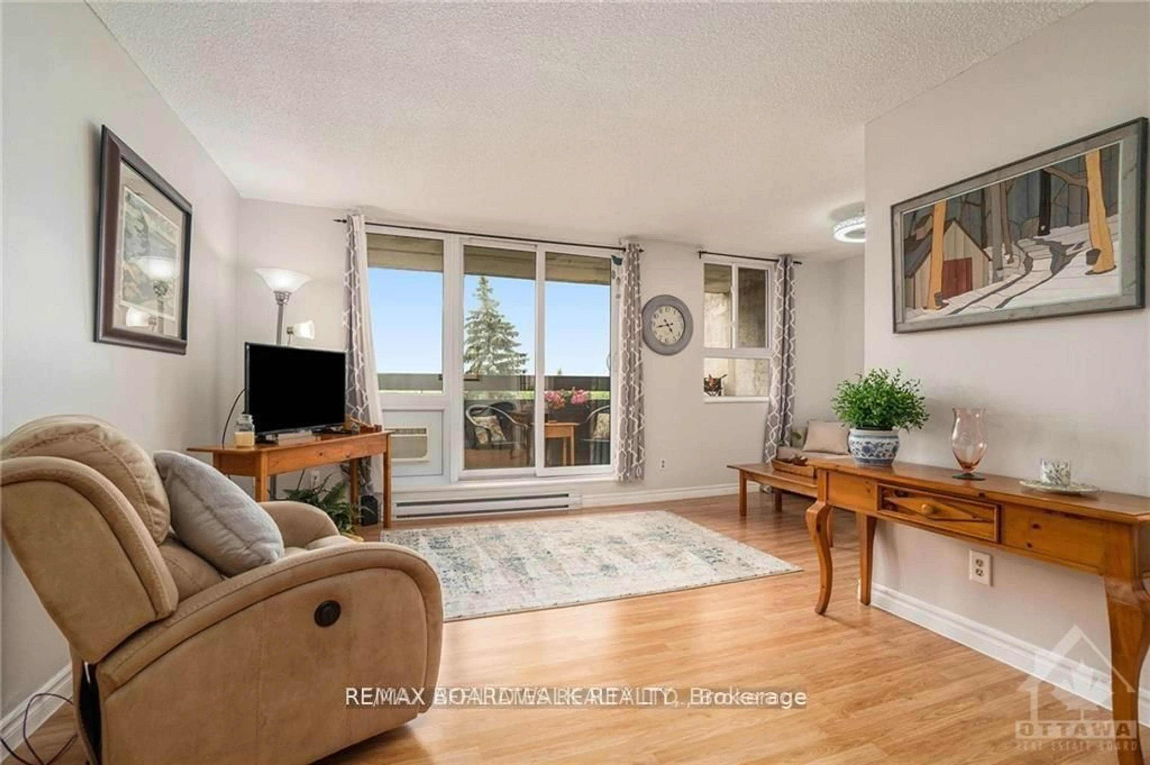 Living room with furniture, wood/laminate floor for 2000 Jasmine Cres #717, Ottawa Ontario K1J 8K4