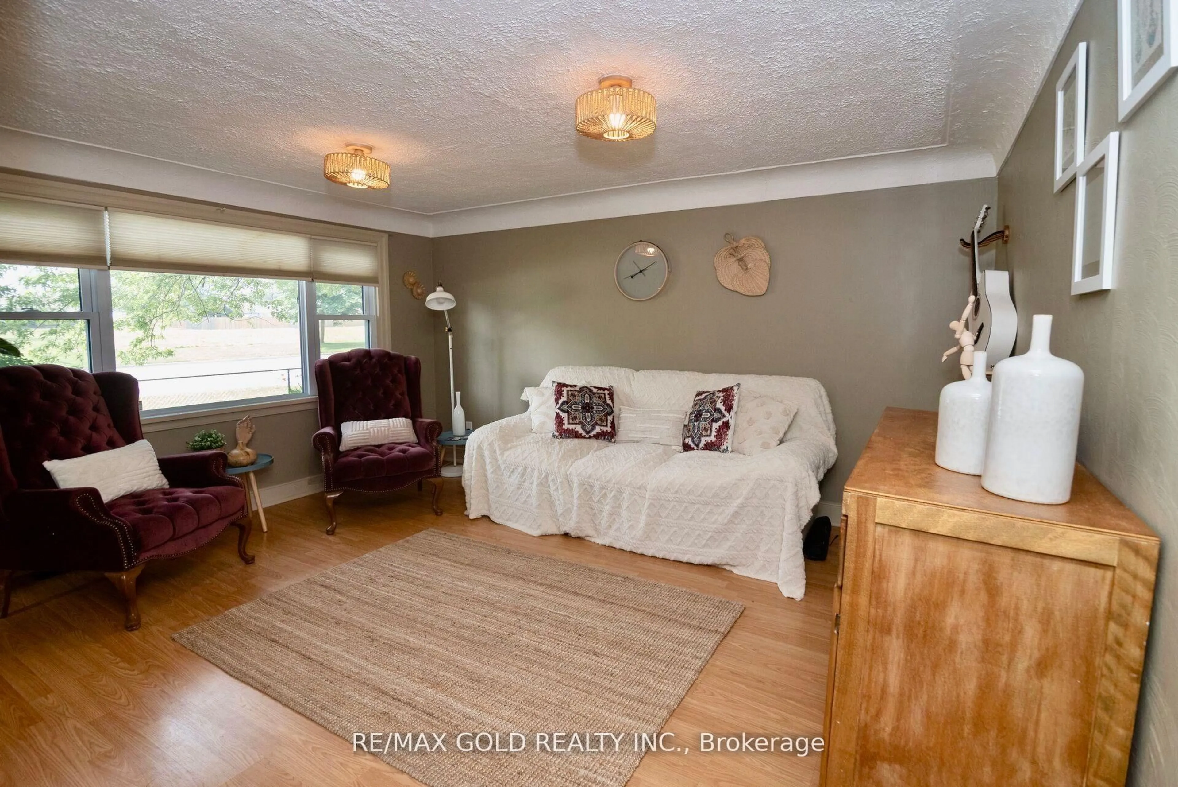 Living room with furniture, wood/laminate floor for 5853 McLeod Rd, Niagara Falls Ontario L2G 3E5
