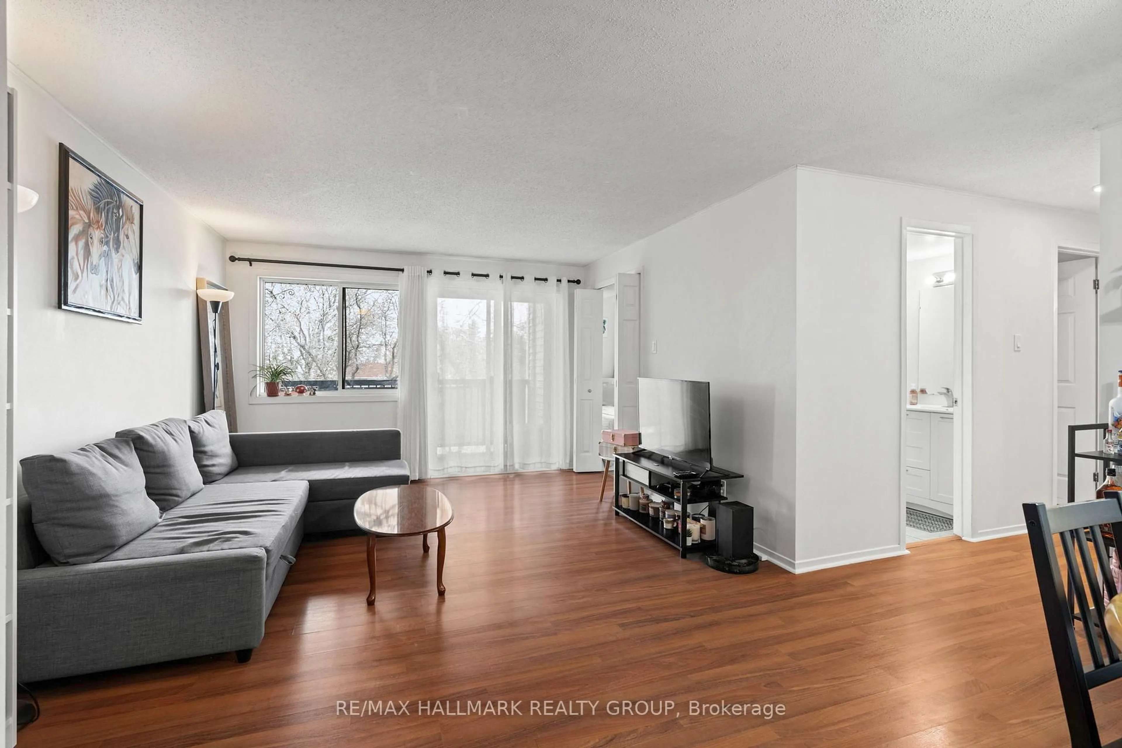 Living room with furniture, wood/laminate floor for 6532 Bilberry Dr #315, Ottawa Ontario K1C 4N9