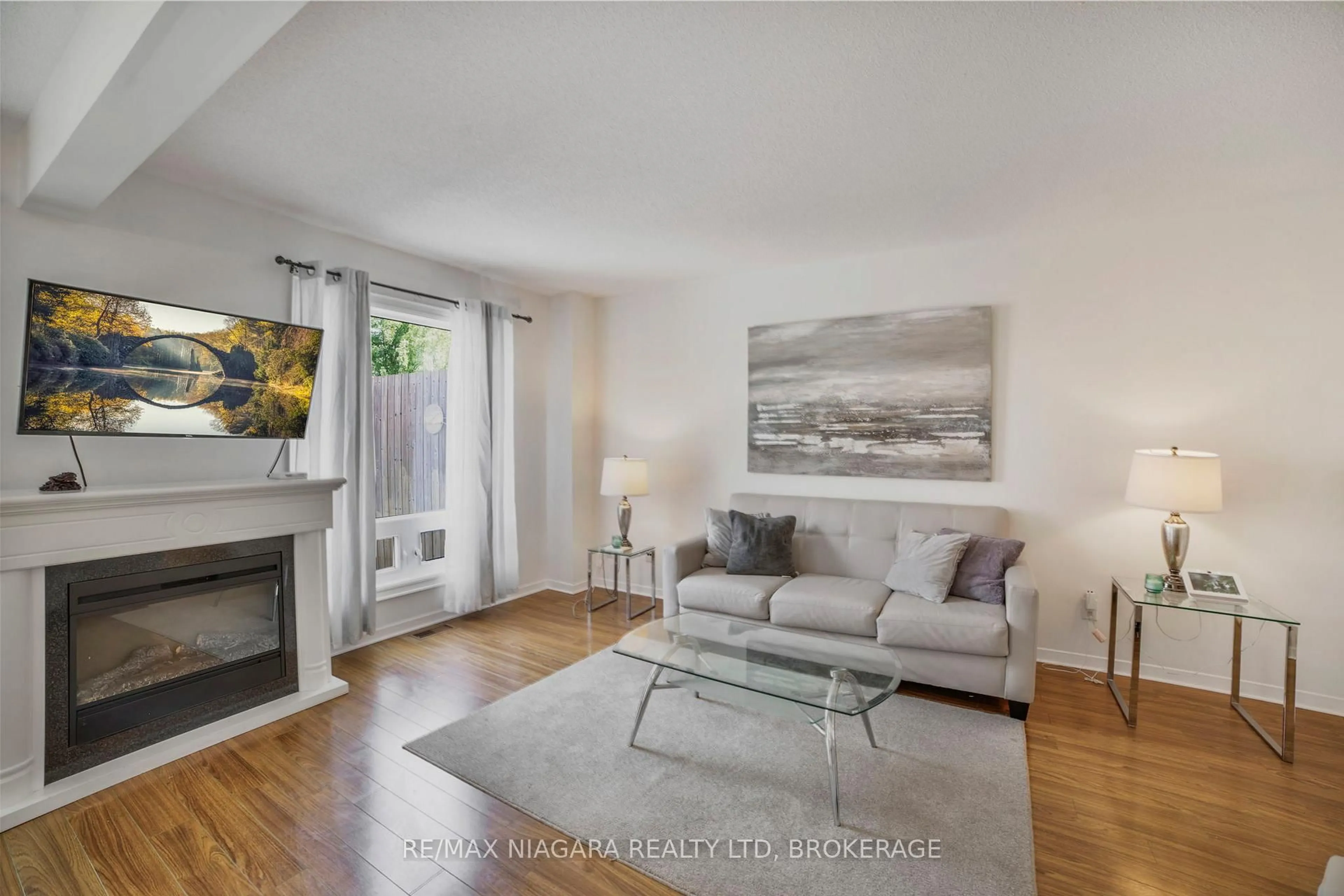 Living room with furniture, wood/laminate floor for 5735 Deerbrook St, Niagara Falls Ontario L2G 7V7