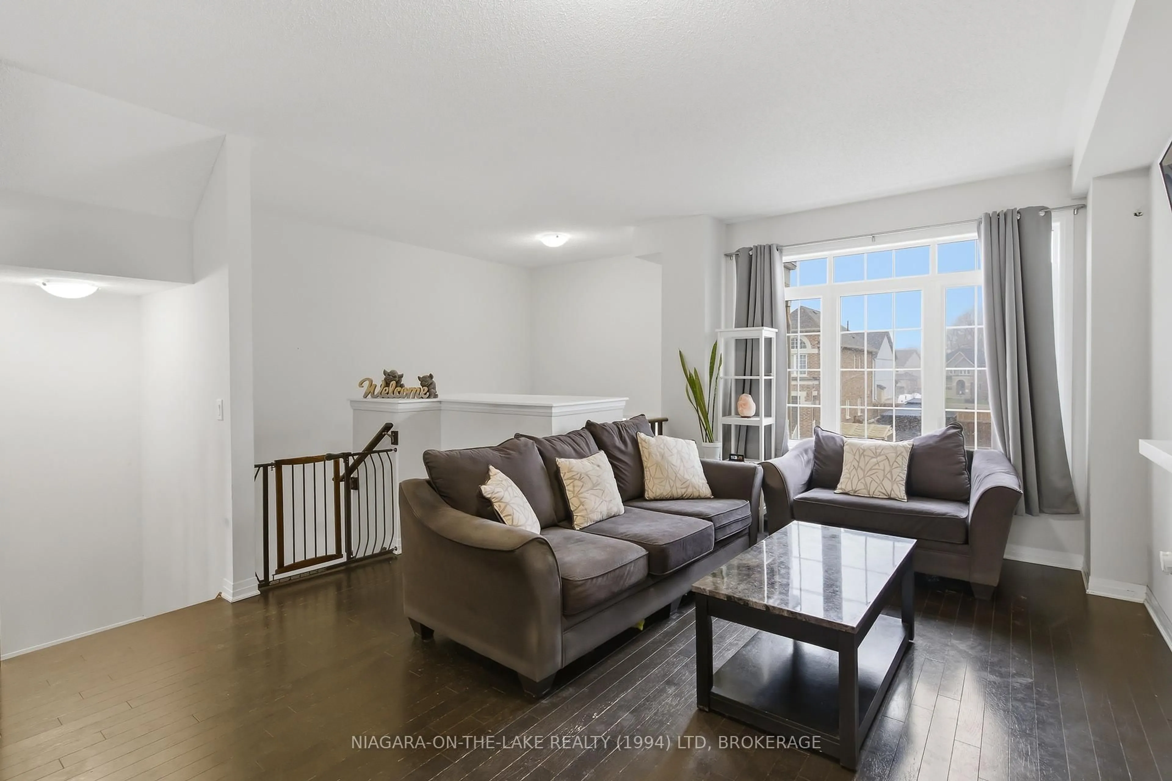 Living room with furniture, wood/laminate floor for 4018 Frachioni Dr, Lincoln Ontario L3J 0R8