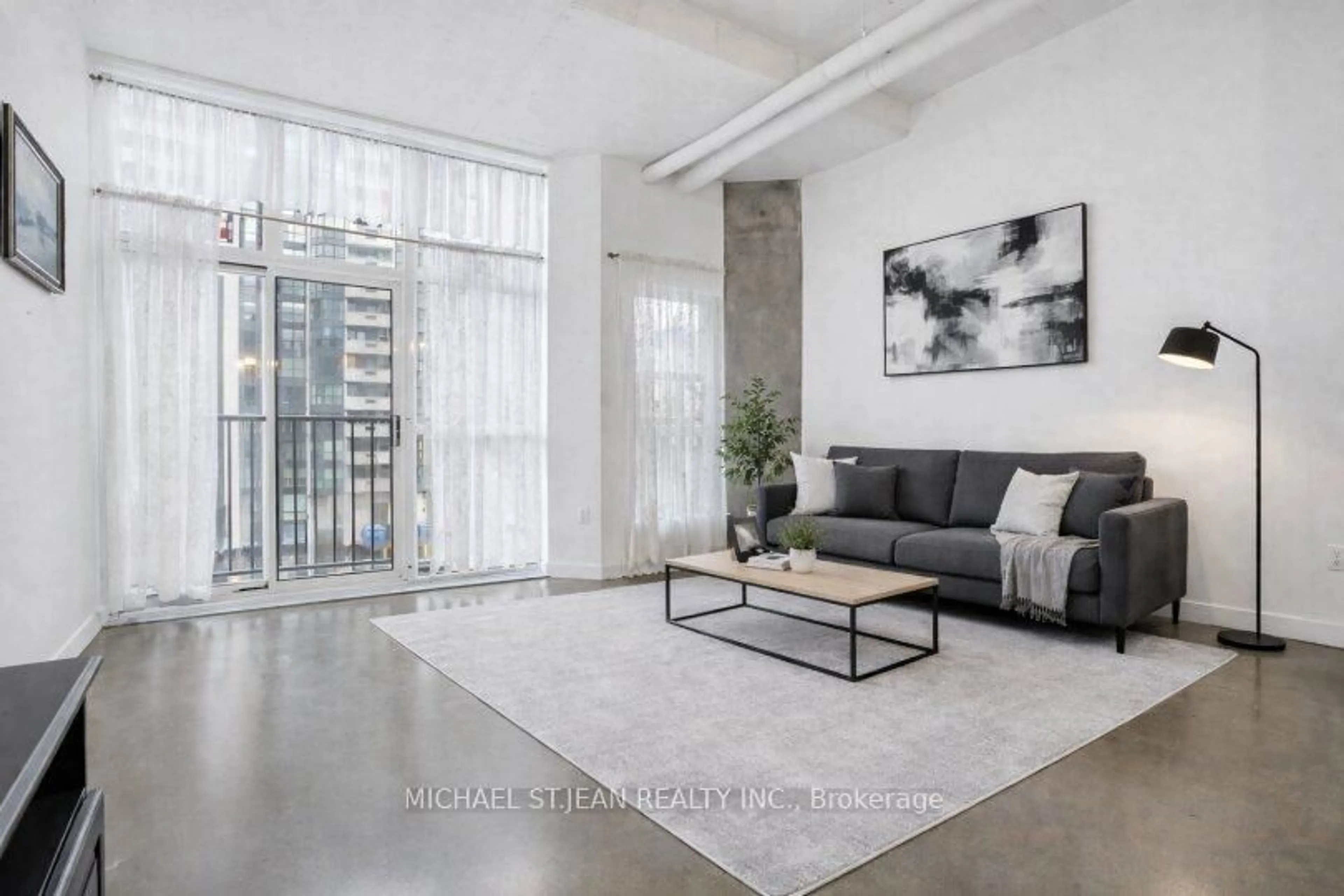 Living room with furniture, cement floor for 66 Bay St #511, Hamilton Ontario L8P 4Z6