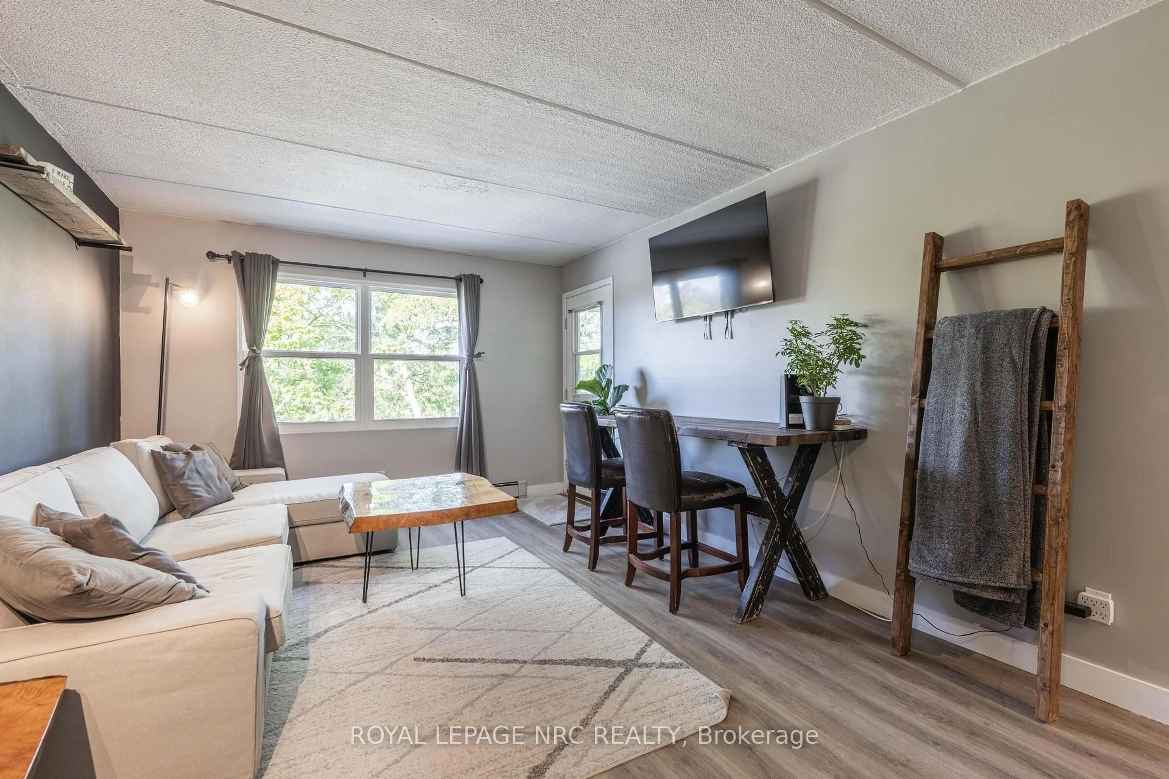 Living room with furniture, wood/laminate floor for 41 Rykert St #207, St. Catharines Ontario L2S 3A4