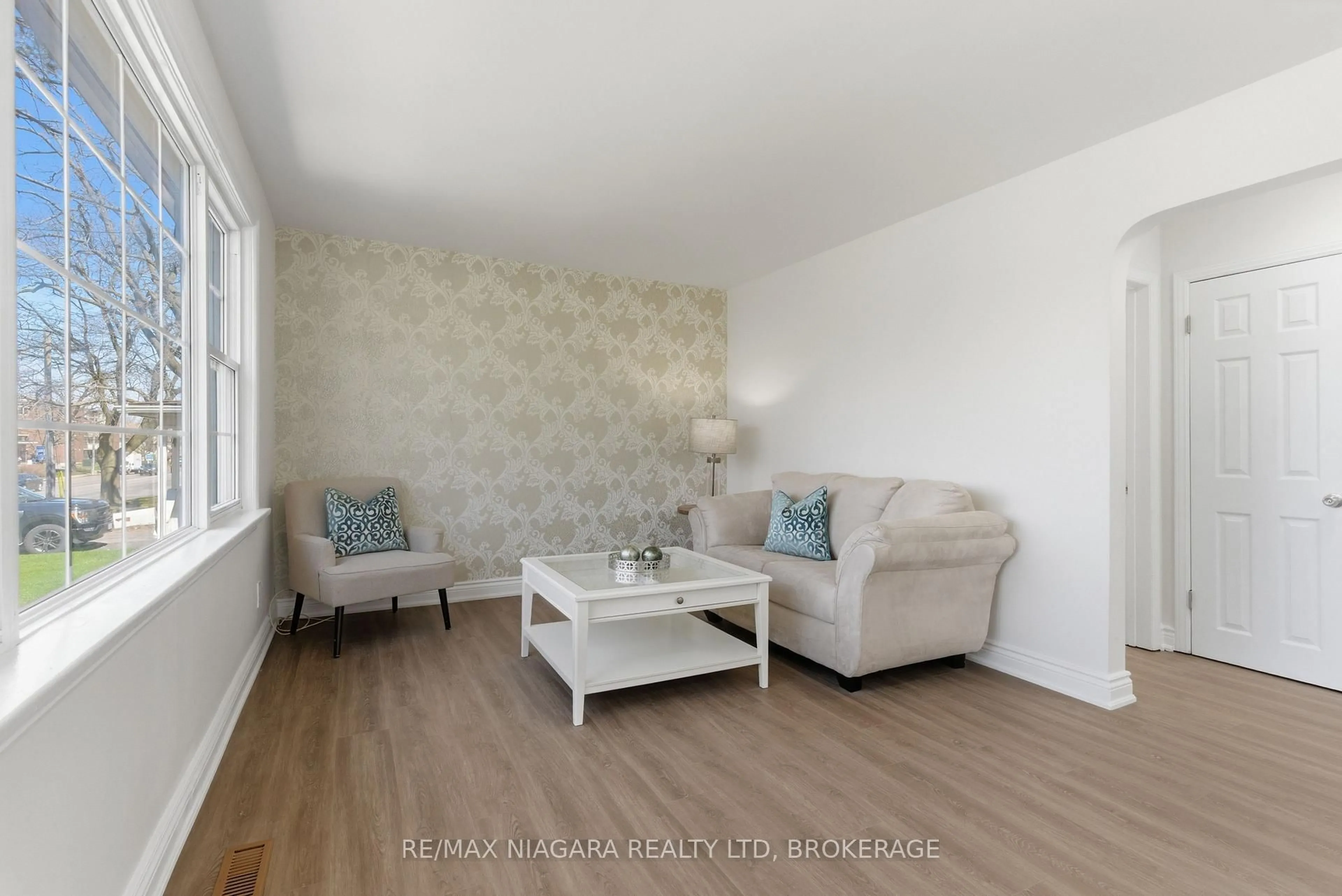 Living room with furniture, wood/laminate floor for 5654 Drummond Rd, Niagara Falls Ontario L2G 4L4