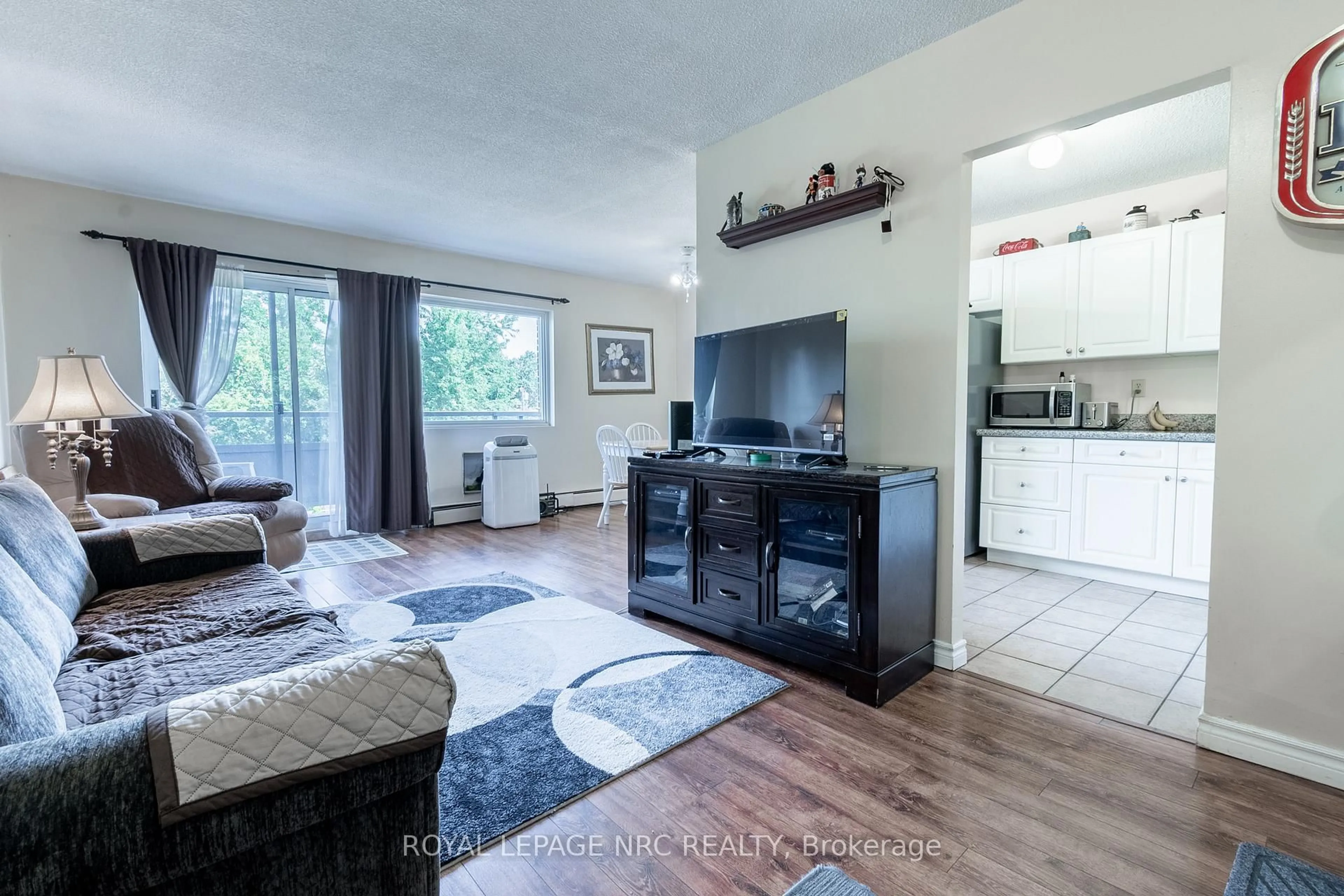 Living room with furniture, wood/laminate floor for 242 Oakdale Ave #316, St. Catharines Ontario L2P 3K5