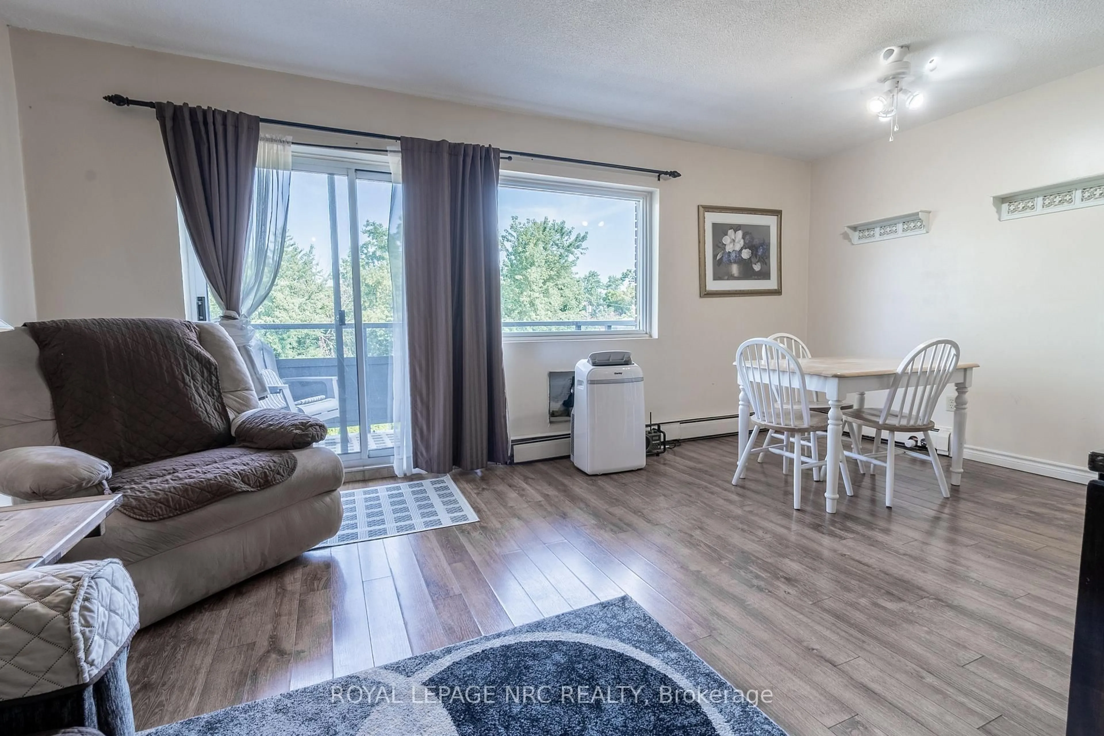 Living room with furniture, wood/laminate floor for 242 Oakdale Ave #316, St. Catharines Ontario L2P 3K5