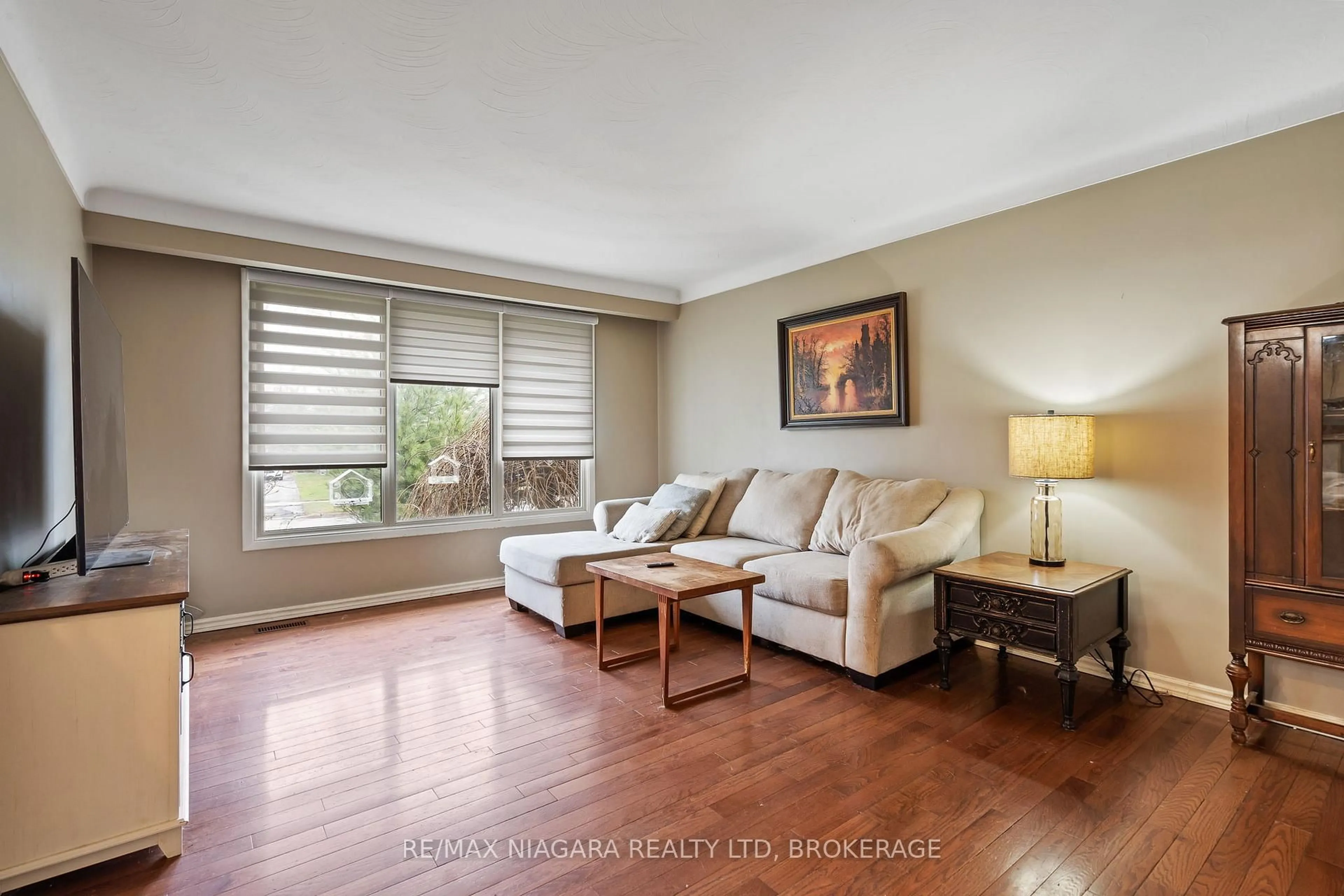 Living room with furniture, wood/laminate floor for 56 Royal Oak Dr, Welland Ontario L3C 5V9