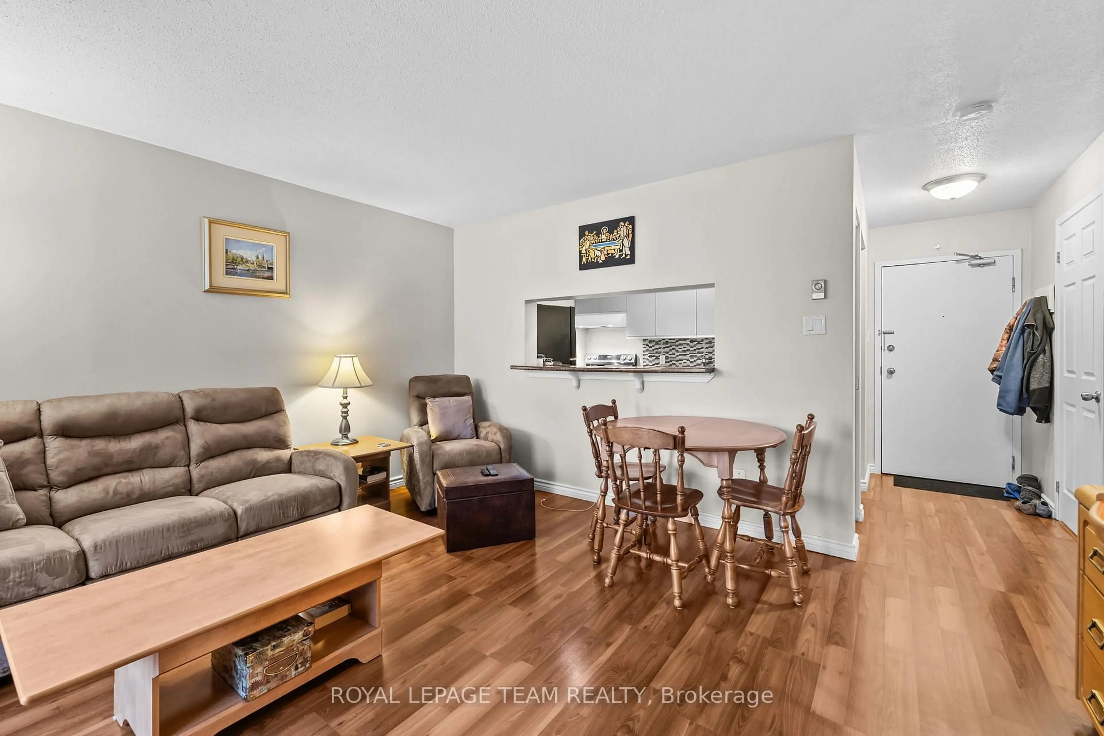 Living room with furniture, wood/laminate floor for 270 Brittany Dr #214, Ottawa Ontario K1K 4M3