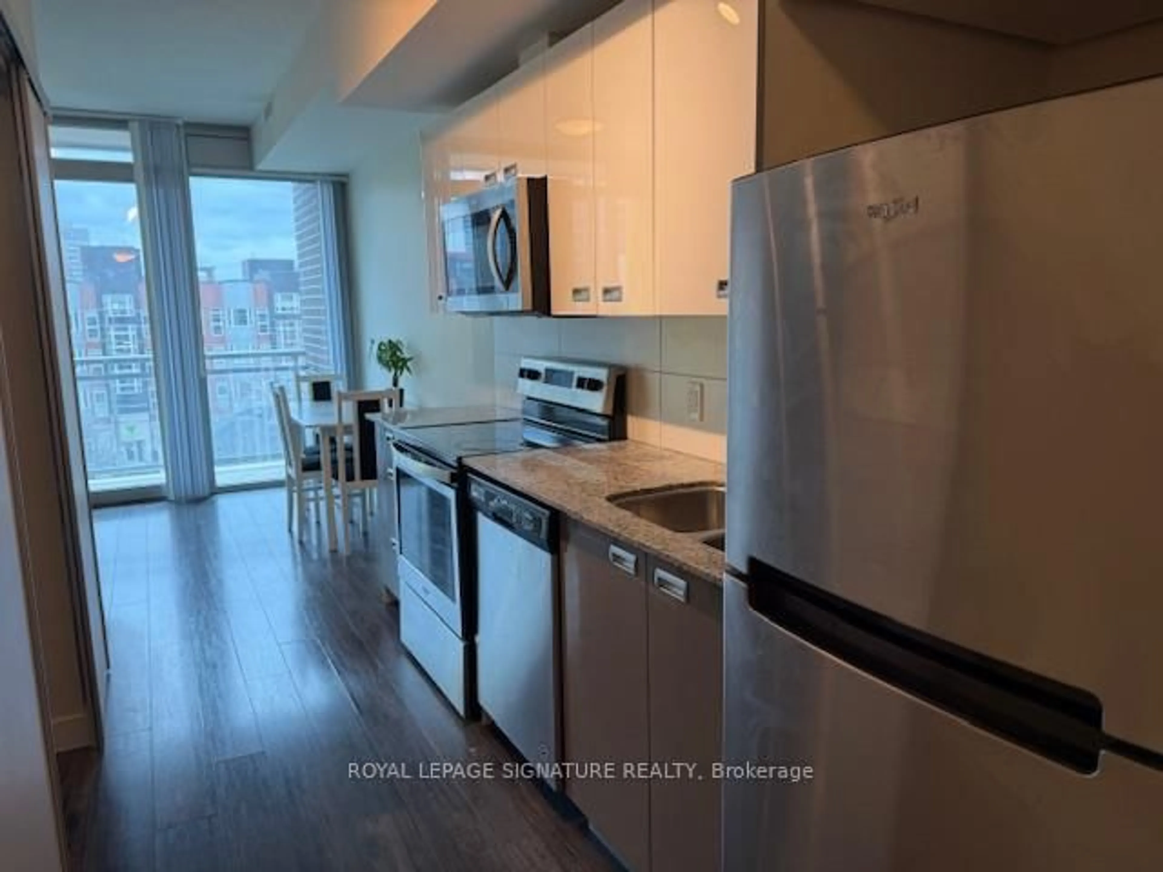 Kitchen with laundary machines, wood/laminate floor for 257 Hemlock St #16, Waterloo Ontario N2L 3R4
